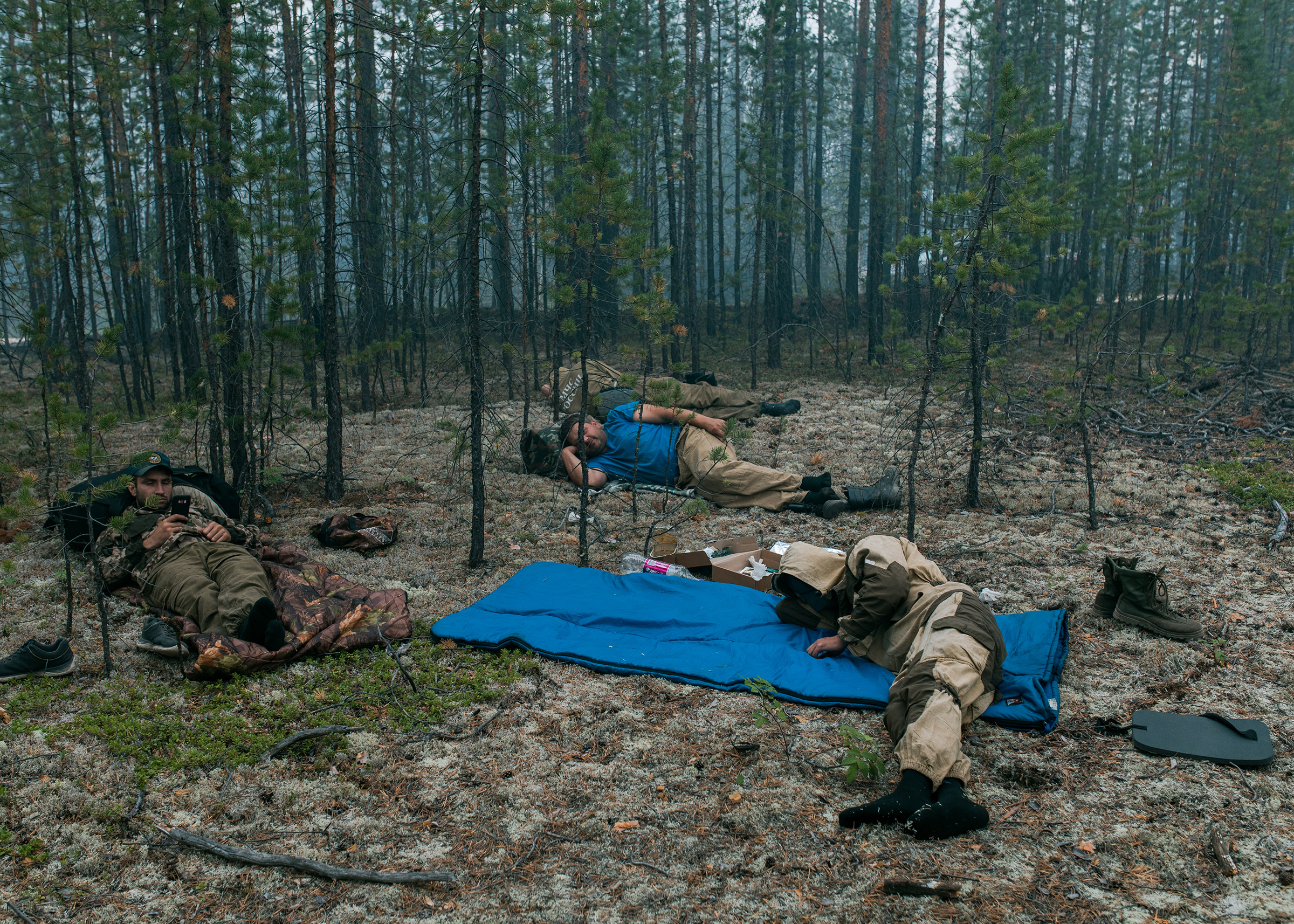 Firefighters of the Ministry of Emergency Situations of the Russian Federation resting after putting out small fires near the village of Dikimdya, on July 15. (Alexey Vasilyev)