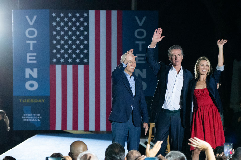 President Joe Biden, California Gov. Gavin Newsom and his wife Jennifer Siebel Newsom wave to the crowd during a campaign event at Long Beach City College in Long Beach, California, U.S., on Monday, Sept. 13, 2021. Polls show Newsom prevailing in the Sept. 14 recall, beating back a mostly Republican field of challengers. (Bing Guan–Bloomberg/Getty Images)