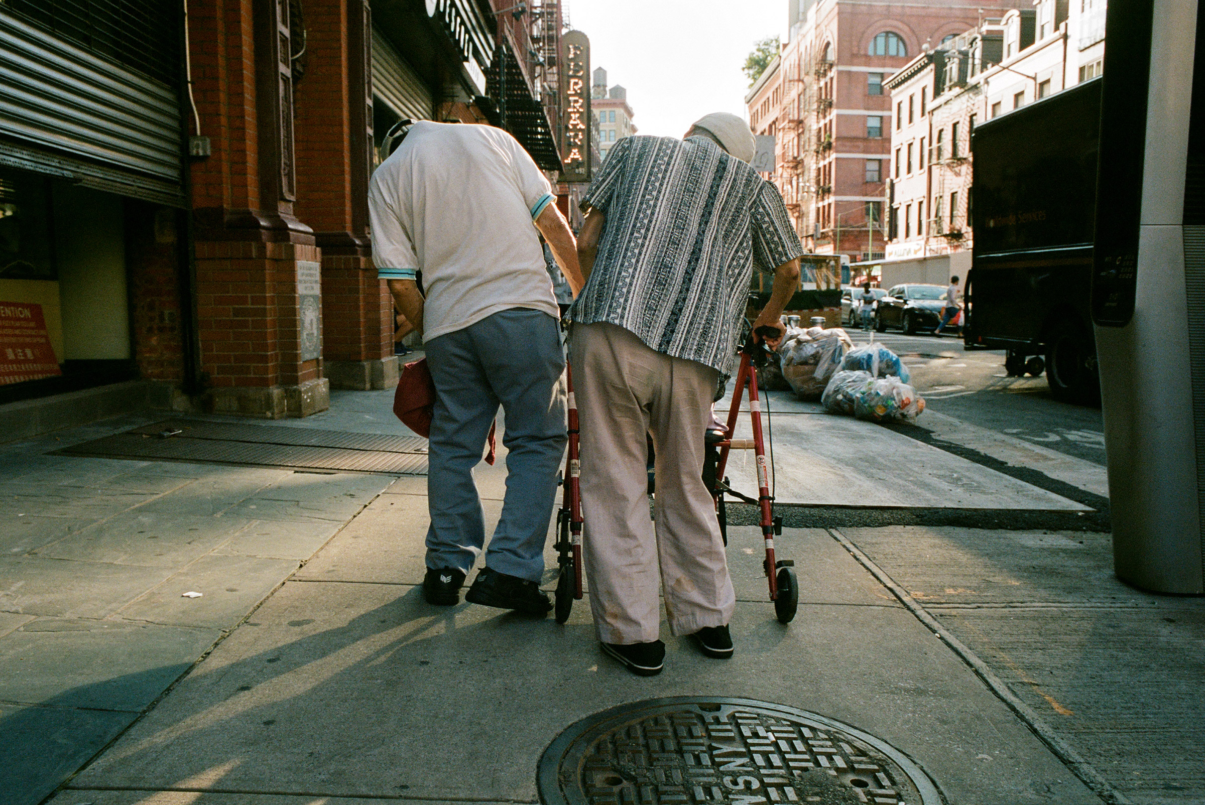 Pedestrians lean on each other in Chinatown, Aug. 27, 2021. (Daniel Arnold for TIME)