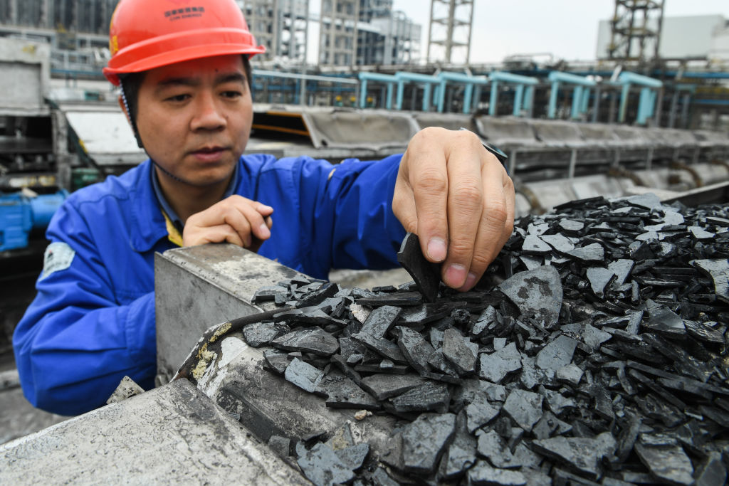 A worker checks byproduct pitch in the coal liquefaction factory belonging to CHN Energy in Ordos, north China's Inner Mongolia Autonomous Region, on April 10, 2019. (Xinhua/Liu Lei via Getty Images)