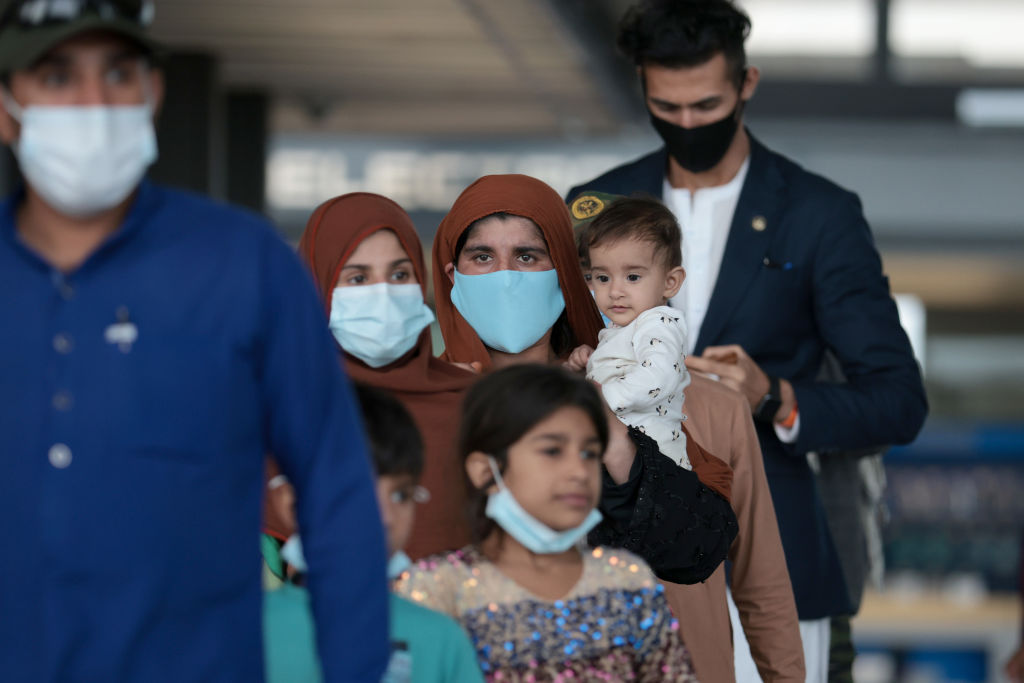 Refugees walk through the departure terminal to a bus at Dulles International Airport after being evacuated from Kabul following the Taliban takeover of Afghanistan on August 31, 2021 in Dulles, Virginia. (Anna Moneymaker-Getty Images)