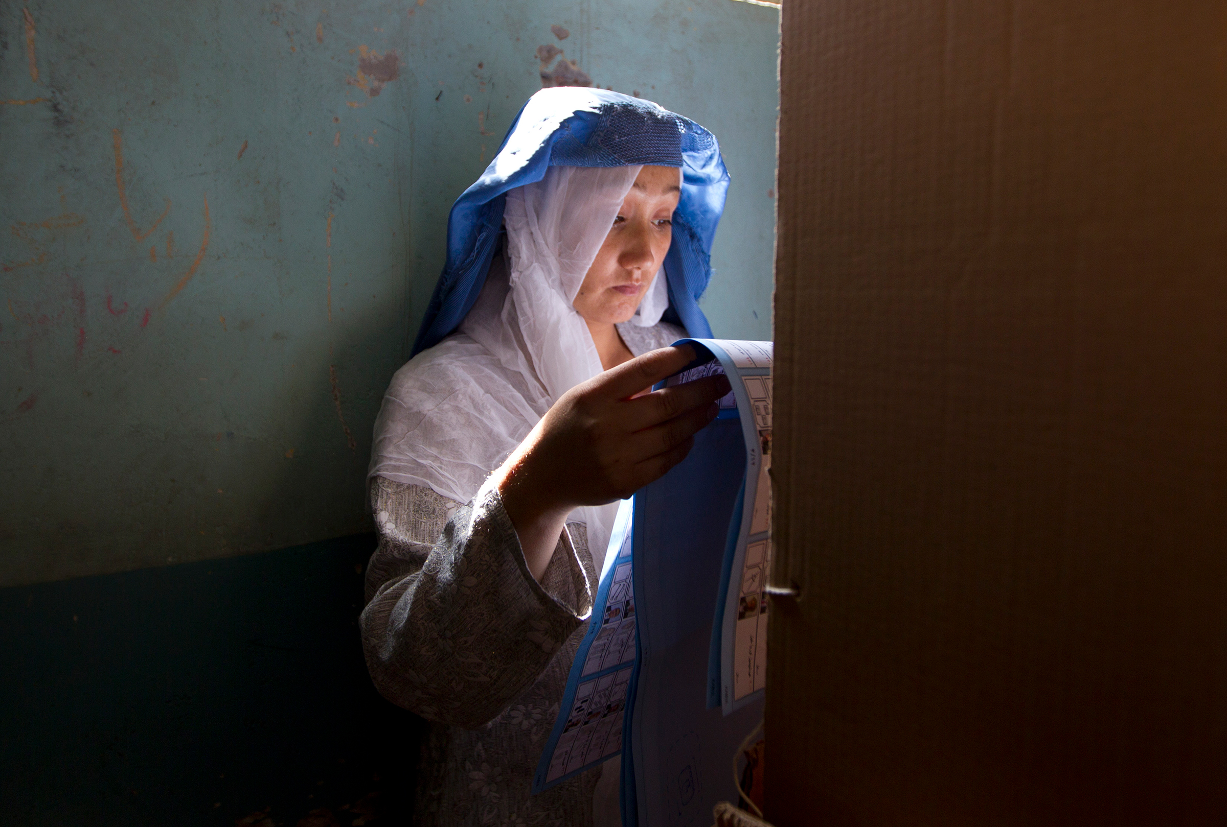 An Afghan woman searches for her candidate in a multiple-page ballot at a mosque in Kabul in September 2010. The Taliban had warned voters to boycott the polls and threatened violence to disturb the country's elections.