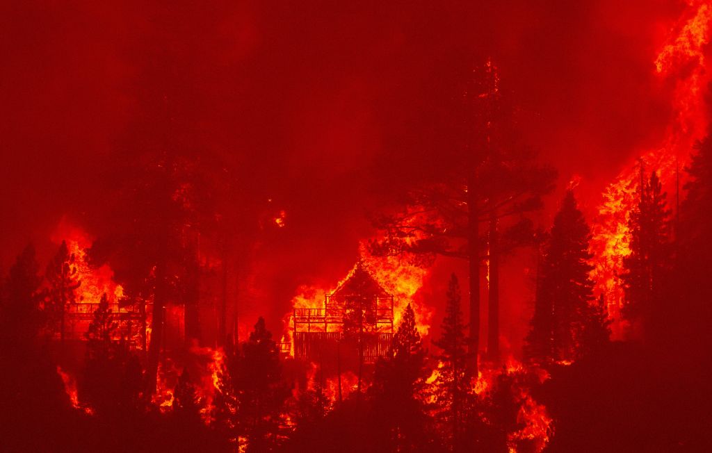 Flames consume multiple homes as the Caldor fire pushes into the Echo Summit area, California on August 30, 2021. - At least 650 structures have burned and thousands more are threatened as the Caldor fire moves into the resort community of South Lake Tahoe, California. Thousands of people were ordered to evacuate Monday as a huge wildfire loomed over a major US tourist spot, filling the air with choking smoke. The Caldor Fire has already torn through more than 270 square miles (700 square kilometers), razing hundreds of buildings. (Photo by JOSH EDELSON / AFP) / The erroneous mention[s] appearing in the metadata of this photo by JOSH EDELSON has been modified in AFP systems in the following manner: [the Echo Summit area] instead of [South Lake Tahoe]. Please immediately remove the erroneous mention[s] from all your online services and delete it (them) from your servers. If you have been authorized by AFP to distribute it (them) to third parties, please ensure that the same actions are carried out by them. Failure to promptly comply with these instructions will entail liability on your part for any continued or post notification usage. Therefore we thank you very much for all your attention and prompt action. We are sorry for the inconvenience this notification may cause and remain at your disposal for any further information you may require. (JOSH EDELSON-AFP)