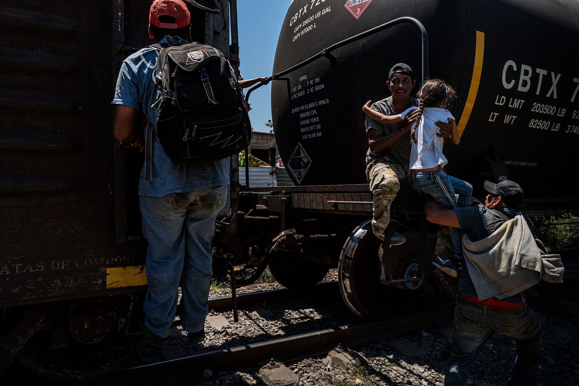 A father helps his young daughter onto a train in Coatzacoalcos in the Mexican state of Veracruz on March 24, 2021. The train, also known as La Bestia, or “The Beast” is part of a larger network of cargo trains to which migrants cling onto in order to migrate north through Mexico. (Yael Martínez—Magnum Photos for TIME)