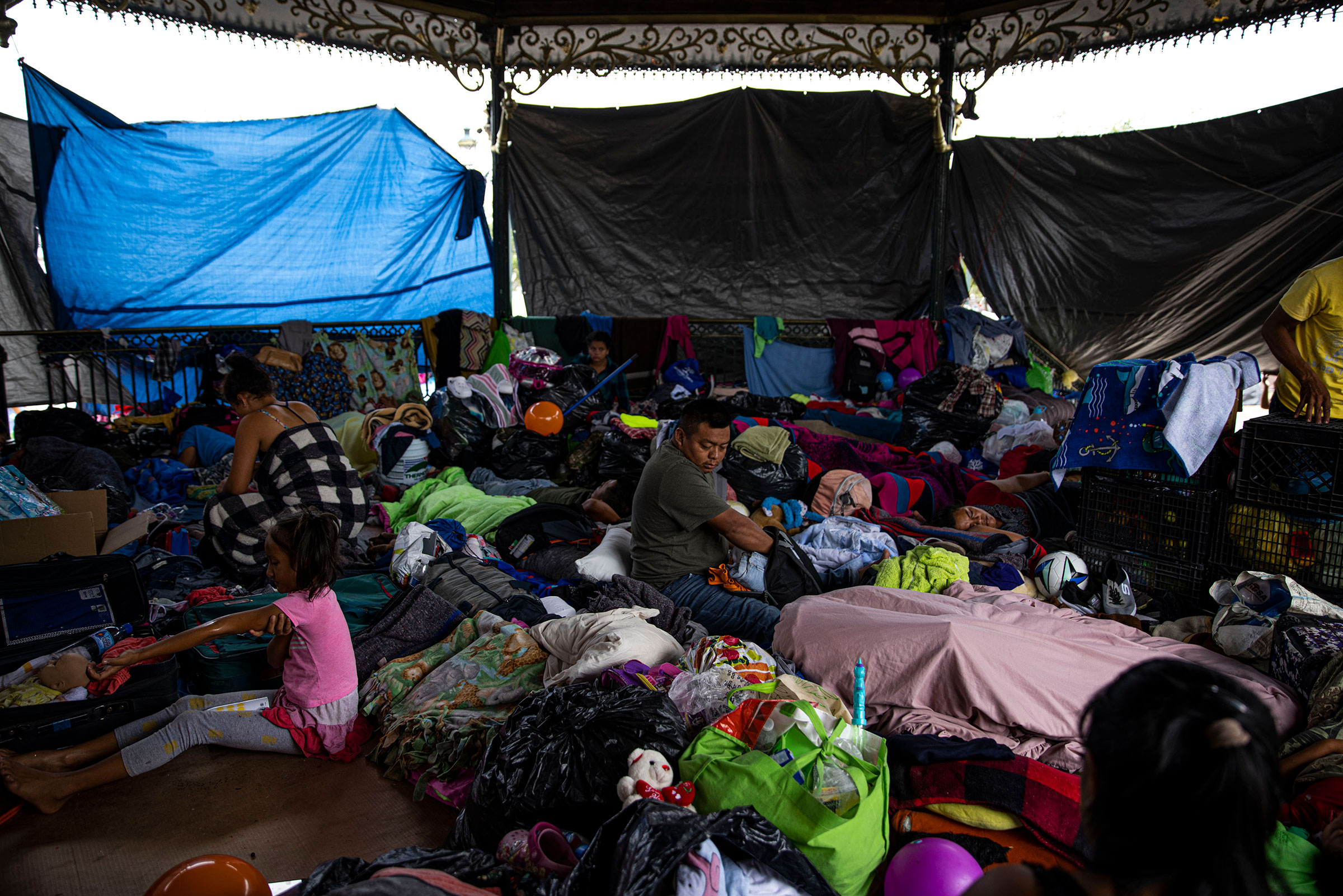Migrants take refuge in a gazebo in Reynosa, Tamaulipas, Mexico on May 6, 2021. Hundreds of migrants have begun living in shelters and a makeshift tent encampment in Reynosa as a result of Title 42, a Trump-era policy that has remained in place under the Biden Administration and allows the government to immediately “expel” anyone who attempts to enter the U.S., even if they wish to make a claim for asylum, because of the risks posed by COVID-19. (Yael Martinez—Magnum Photos for TIME)
