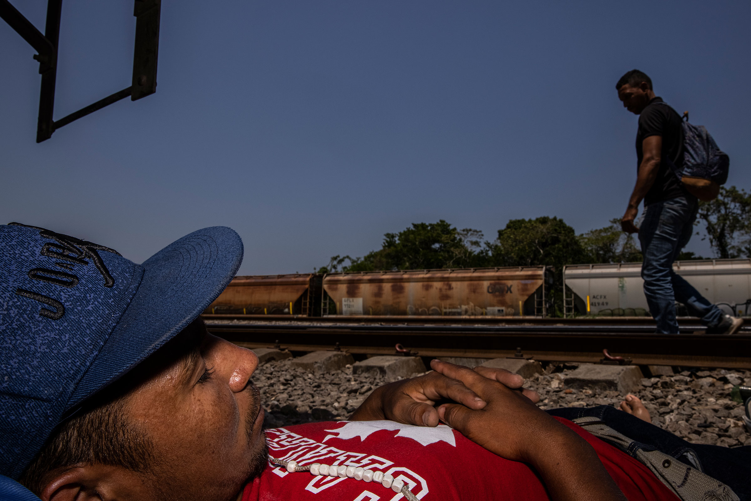 Jesus Antonio Carrillo Mendoza, 28, takes a nap in Higueras in the Mexican state of Veracruz, on March 23, 2021 near cargo trains used by migrants to travel northward through Mexico. He has been traveling for 15 days since leaving his home in Comayagua, Honduras. (Yael Martínez—Magnum Photos for TIME)
