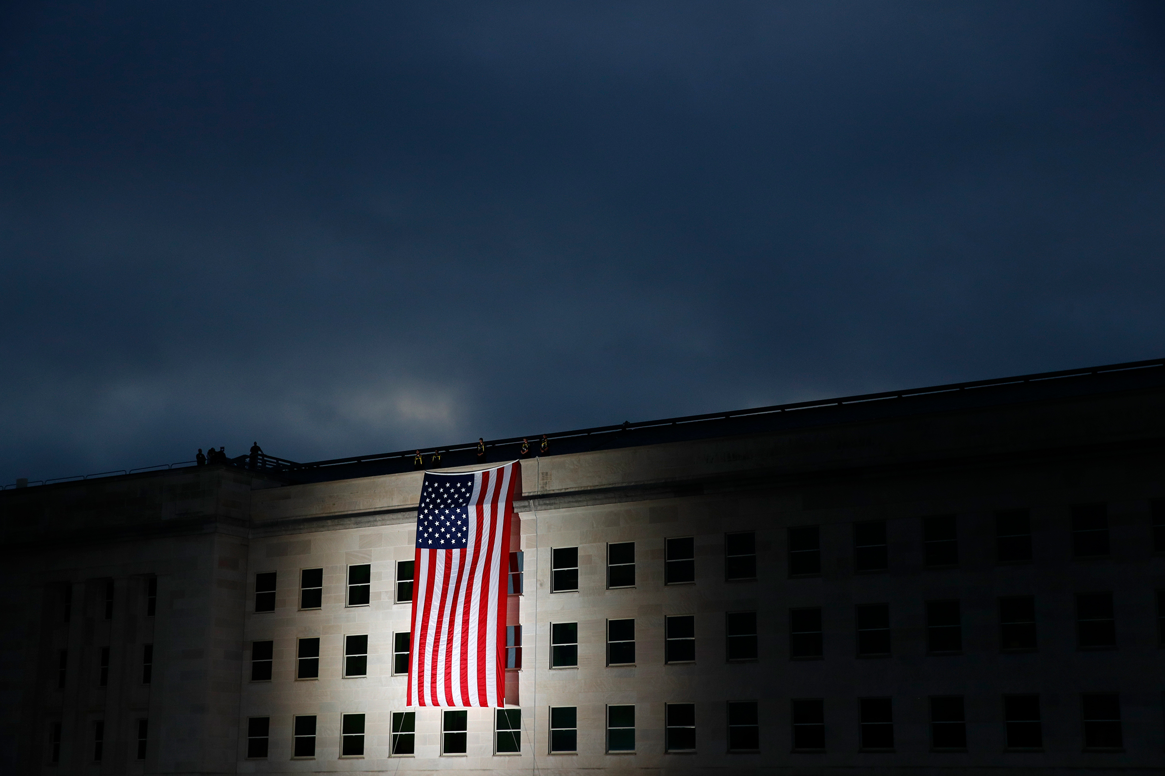 An American flag is unfurled at sunrise at the Pentagon in Washington, D.C., on Sept. 11, 2019, the 18th anniversary of the attacks. (Patrick Semansky—AP)