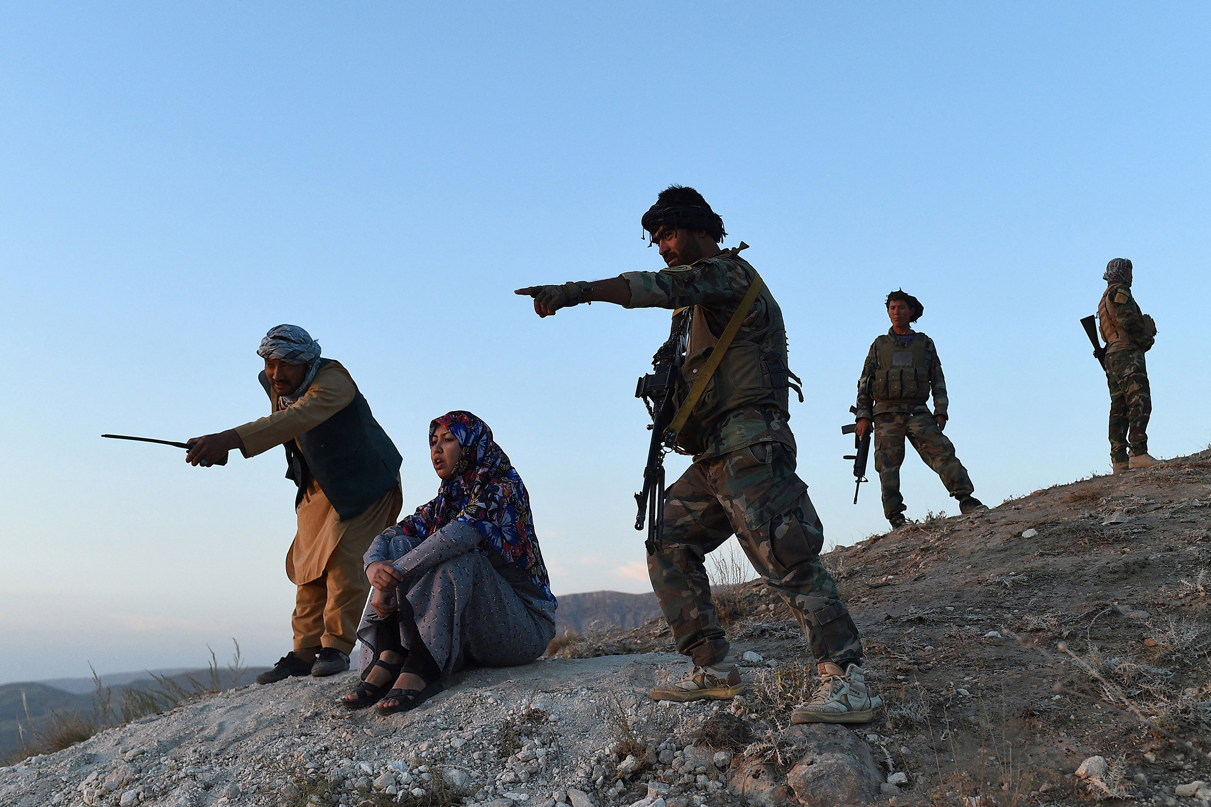 District governor Salima Mazari (second from left) looks on from a hill while accompanied by security personnel near the frontlines against the Taliban, at Charkint district in Balkh province, Afghanistan, on July 14. (Farshad Usyan—AFP/Getty Images)