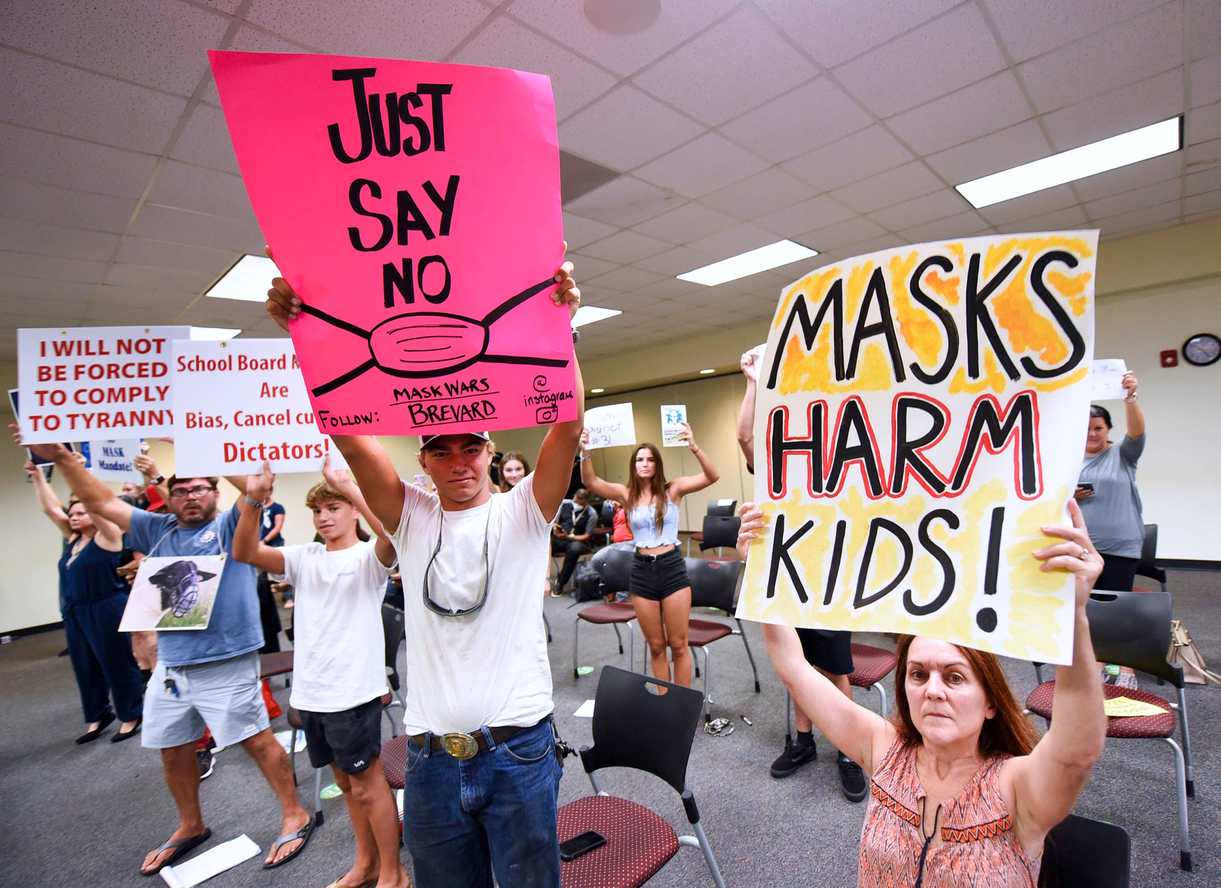 People demonstrate with placards at an emergency meeting of