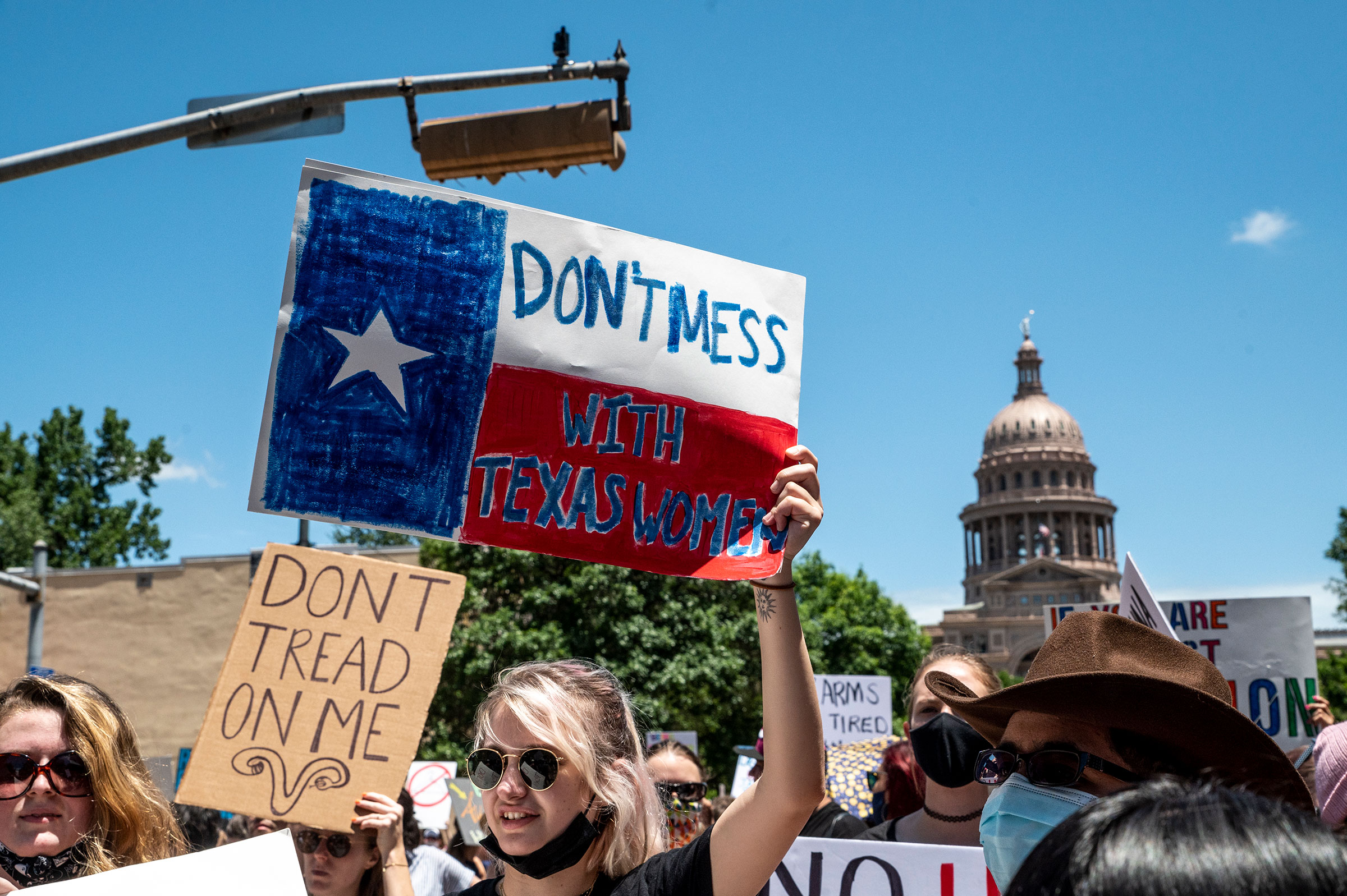 Protesters hold up signs as they march down Congress Ave at a protest outside the Texas state capitol in Austin on May 29, 2021. (Sergio Flores—Getty Images)