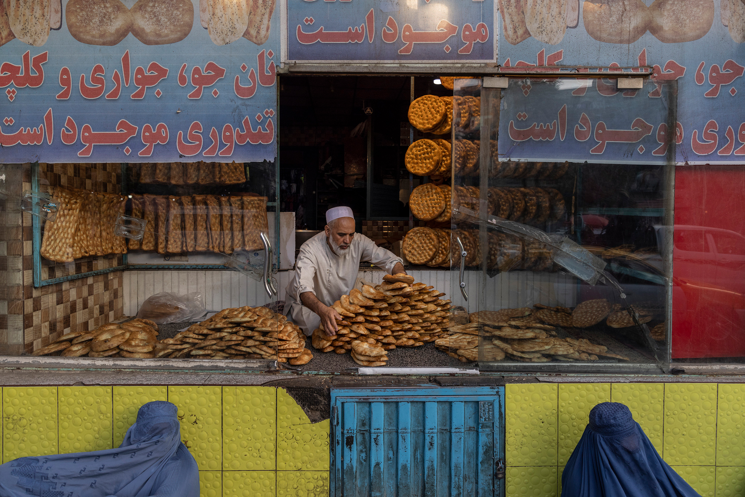 Two women beg for alms outside a bakery in Kabul on Sept. 13, 2021.
