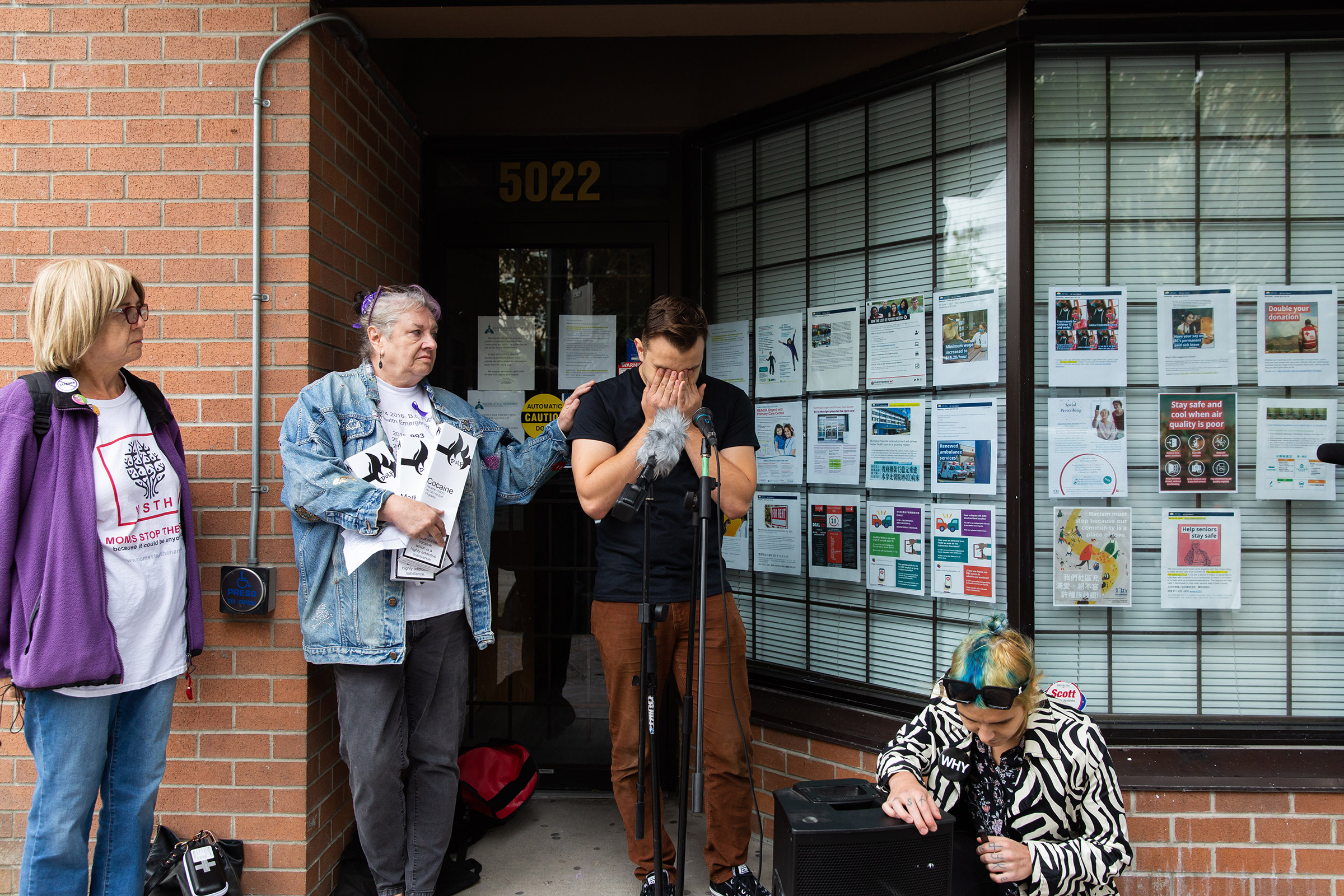 Deb Bailey (middle), co-founder of Moms Stop The Harm, holds boxes of drugs for distribution. She comforts Jeremy Kalicum, co-founder of the Drug User Liberation Front during his speach at a press conference on International Overdose Awareness Day in front of Health Minister Adrian Dix's office in Vancouver, B.C. August 31, 2021. Jackie Dives