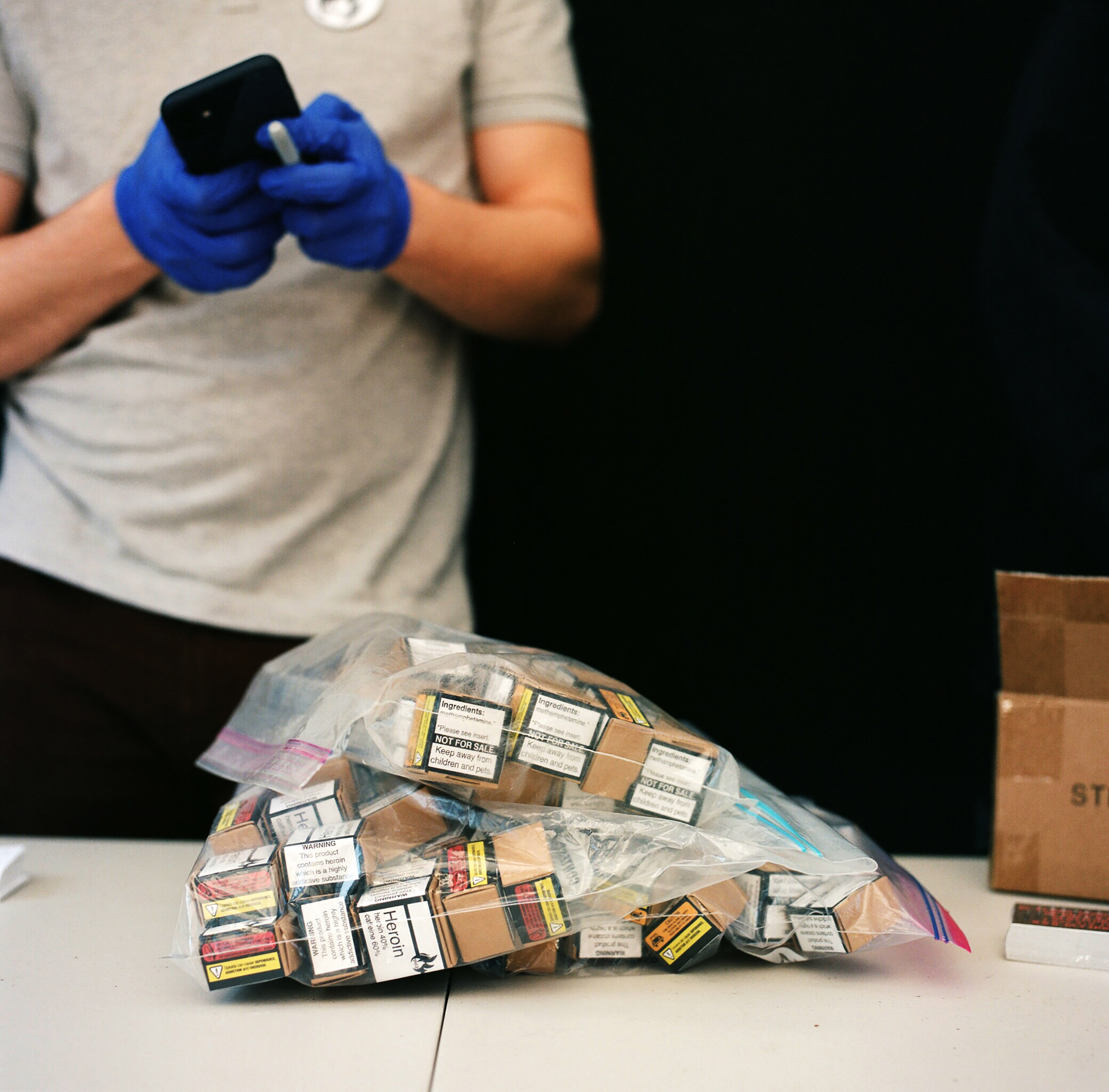 A member of the Drug User Liberation Front hands out illegal drugs that have been tested and determined to be free of fentanyl, then packaged and given warning labels similar to those on cigarette packs, at an event on April 14, 2021. (Jackie Dives)