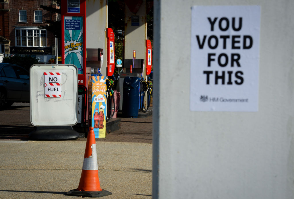 A political protest poster created by urban artist 'Bod,' at a petrol station on Oct. 1, 2021 in Weymouth, United Kingdom. (Finnbarr Webster—Getty Images)