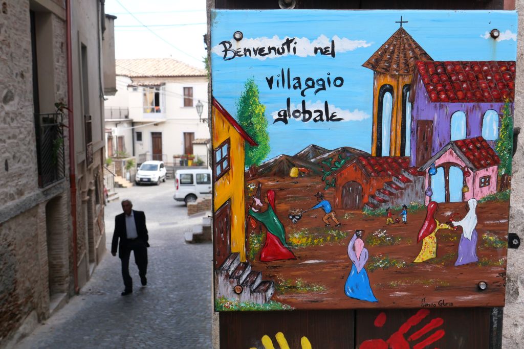 A welcoming sign reading "Welcome to the Global Village" is pictured in the small town of Riace, southern Italy, on June 4, 2019 (Alberto Pizzoli—AFP via Getty Images)