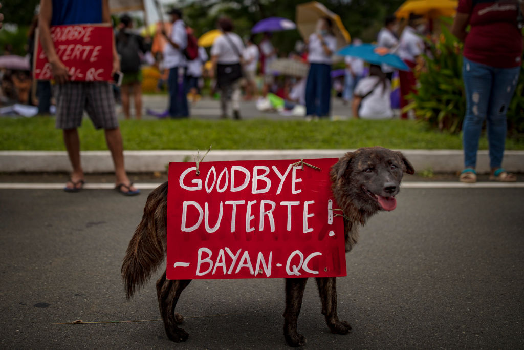 A dog is seen with placard as Filipino protesters attempt to march towards Philippine Congress to call for an end to Duterte's presidency on July 26, 2021 in Manila, Philippines. (Ezra Acayan/Getty Images)
