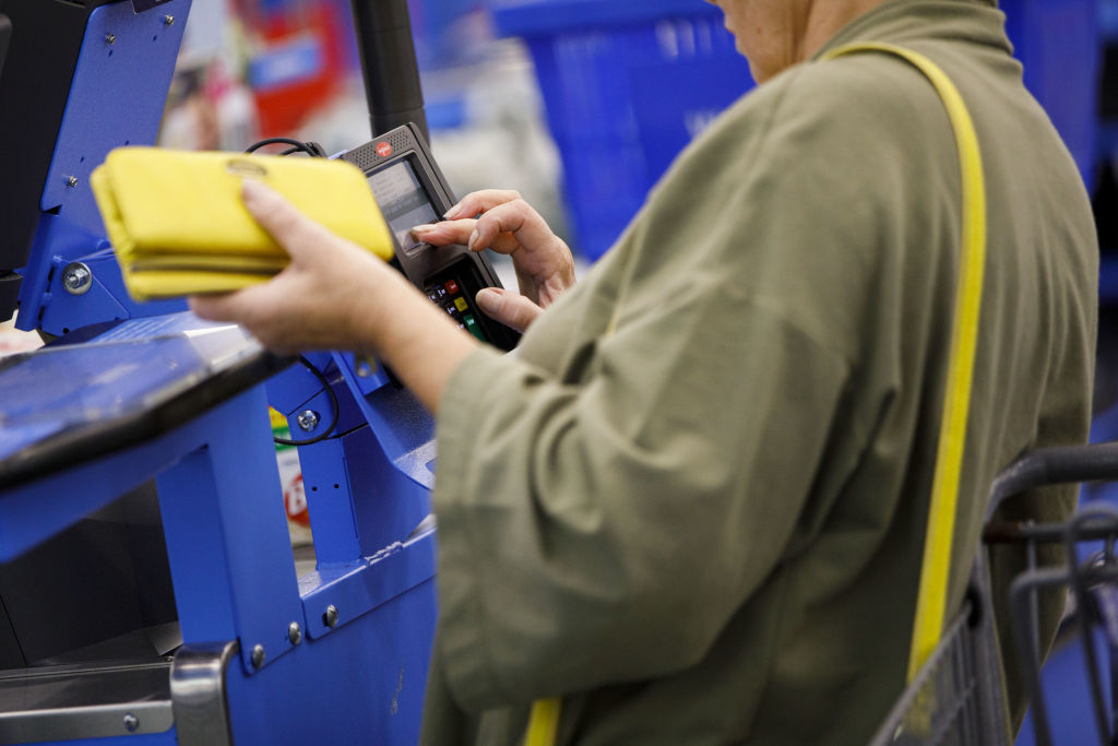 A customer uses a credit card terminal to complete a purchase at a Wal-Mart Stores Inc. location in Burbank, California, U.S., on Thursday, Nov. 16, 2017. (Patrick T. Fallon/Bloomberg via Getty Images)