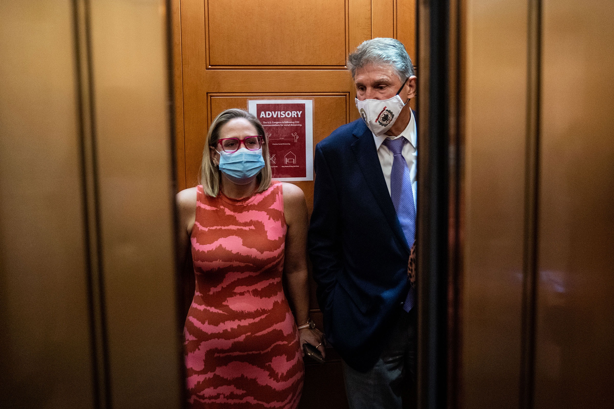 Sen. Kyrsten Sinema and Sen. Joe Manchin in the elevator on their way to go to the Senate Chamber on Sept. 30, 2021 on Capitol Hill in Washington. (Kent Nishimura—Los Angeles Times/Getty Images)