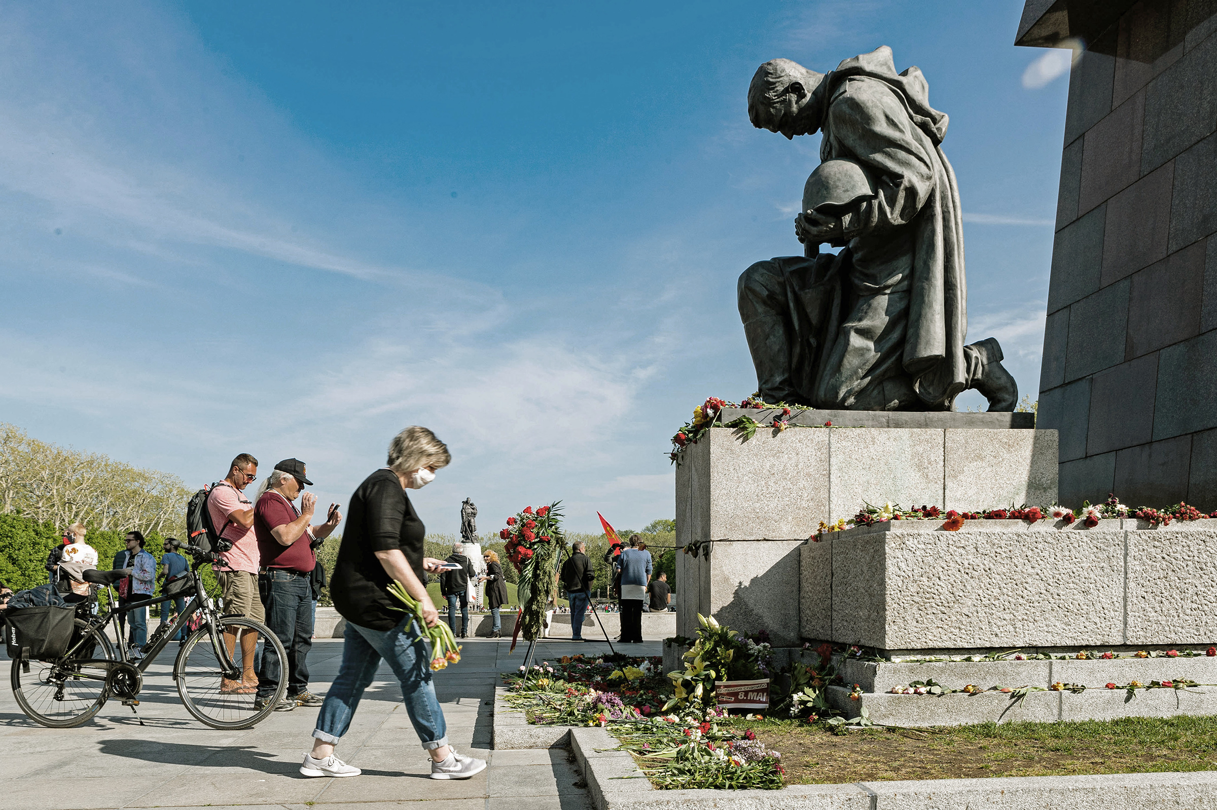 A woman lays flowers in front of a statue of a Soviet soldier at the Soviet Memorial in Treptower Park in Berlin on May 8, 2020. (Binh Truong Xinhua—eyevine/Redux)
