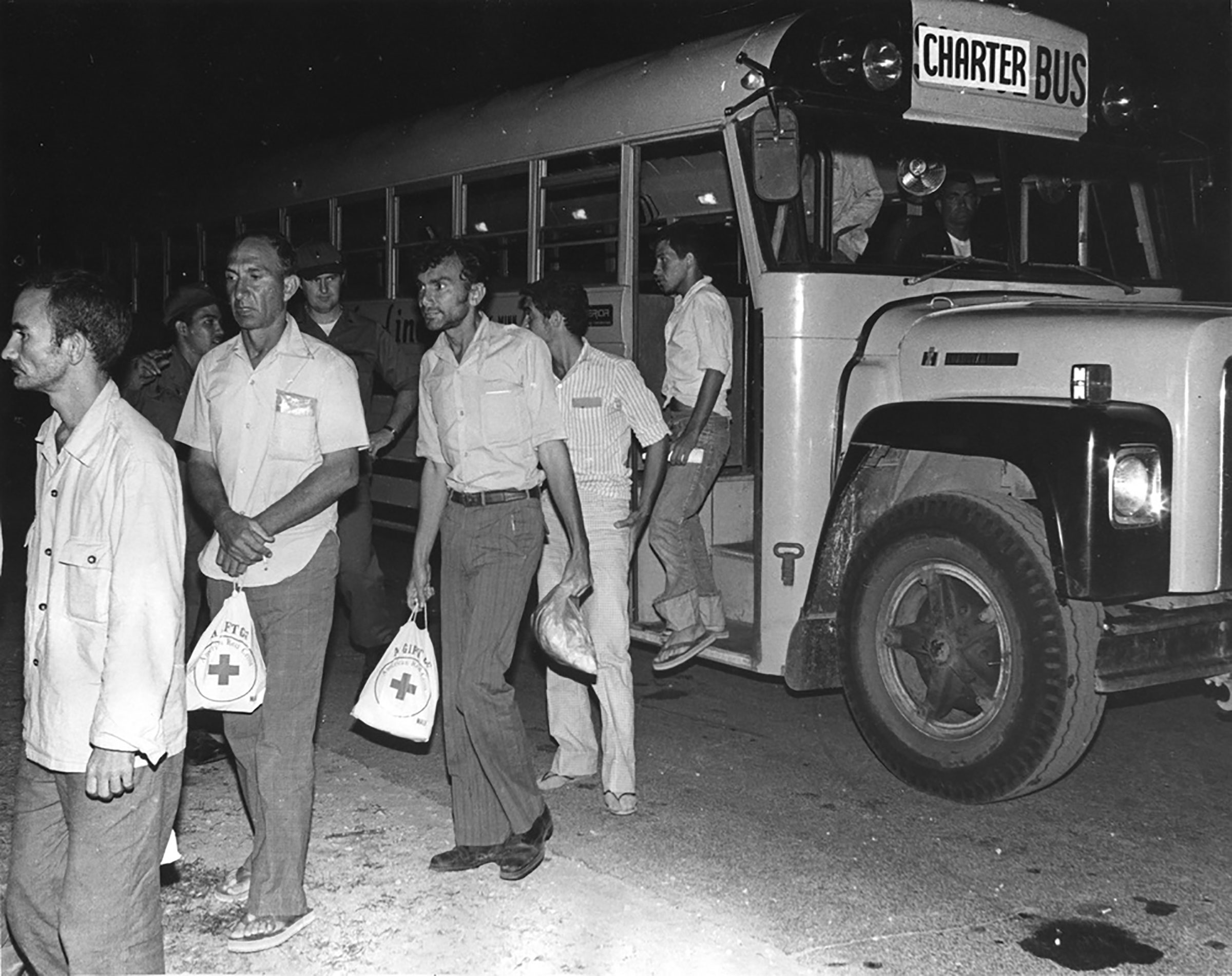 Cuban refugees step off a bus and into a holding area at Fort McCoy in 1980 after a ride from the La Crosse Municipal Airport. Fort McCoy served as a processing center for Cuban refugees from the Mariel Boatlift. (Mary Bower—Courtesy U.S. Army)
