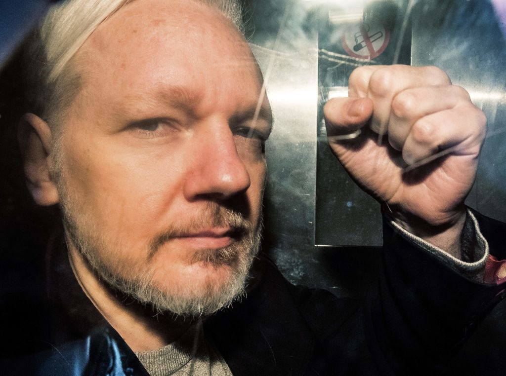 WikiLeaks founder Julian Assange gestures from the window of a prison van as he is driven into Southwark Crown Court in London on May 1 2019, before being sentenced to 50 weeks in prison for breaching his bail conditions in 2012. (Daniel Leal-Olivas—AFP/Getty Images)