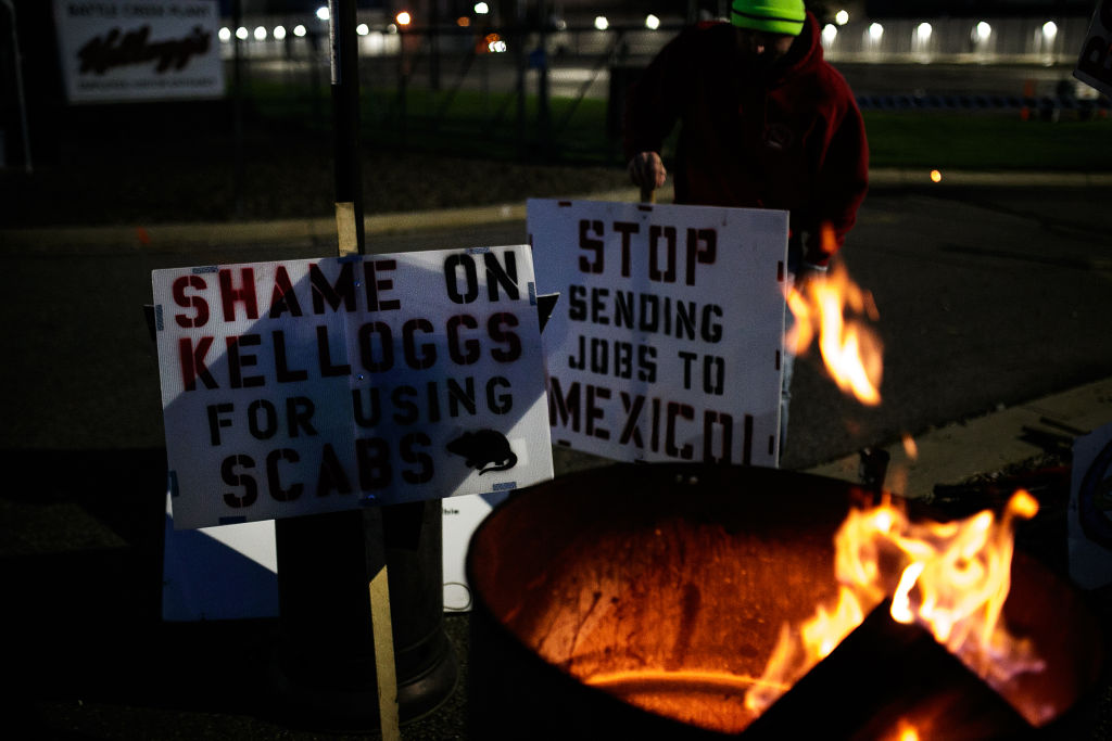 Signs by a fire during a union workers strike outside the Kellogg plant in Battle Creek, Michigan, U.S., on Friday, Oct. 22, 2021. (Jenifer Veloso/Bloomberg via Getty Images)