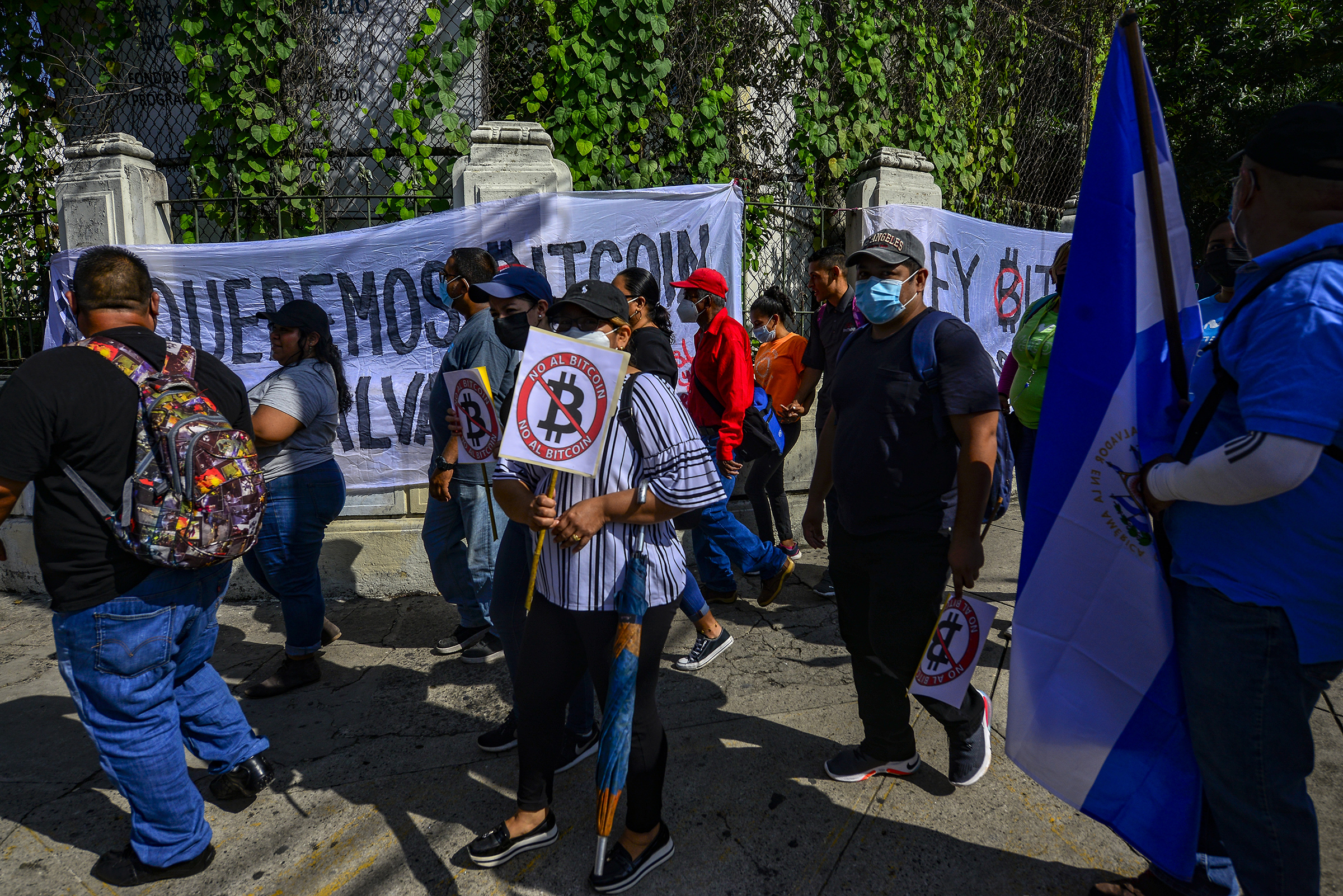 Demonstrators hold signs during a protest against President Bukele and Bitcoin in San Salvador on Sept. 15, 2021. (Camilo Freedman—Bloomberg/Getty Images)