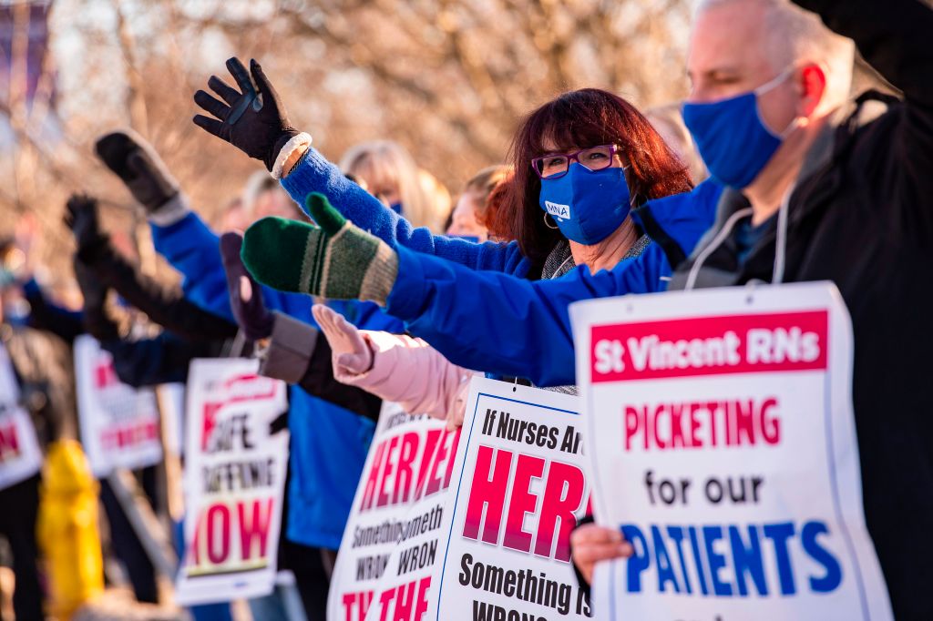 Registered Nurses and supporters stand in a picket line and wave to cars as they drive by outside St. Vincent Hospital in Worcester, Massachusetts on February 24, 2021. (JOSEPH PREZIOSO/AFP via Getty Images)