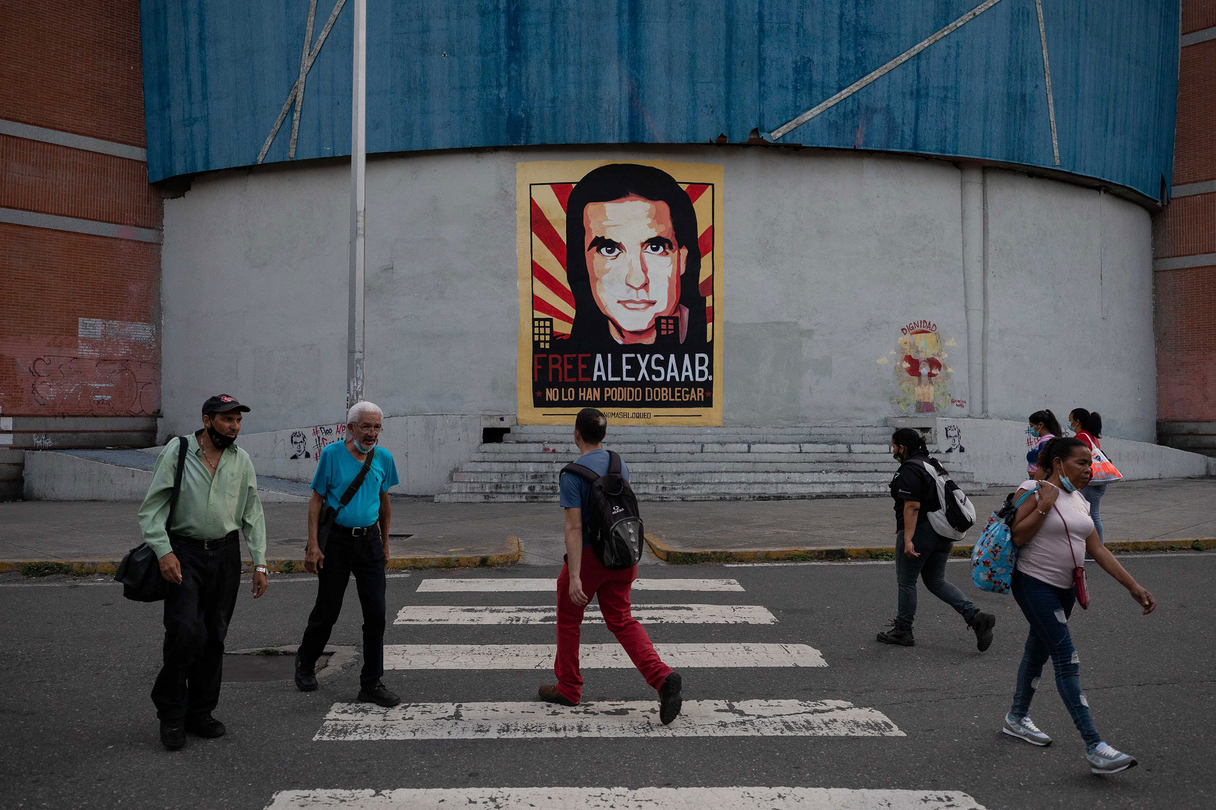 People walk in front of a mural with the image of Alex Saab in Caracas, Venezuela, October 25, 2021. (Rayner Pena—EPA-EFE/Shutterstock)