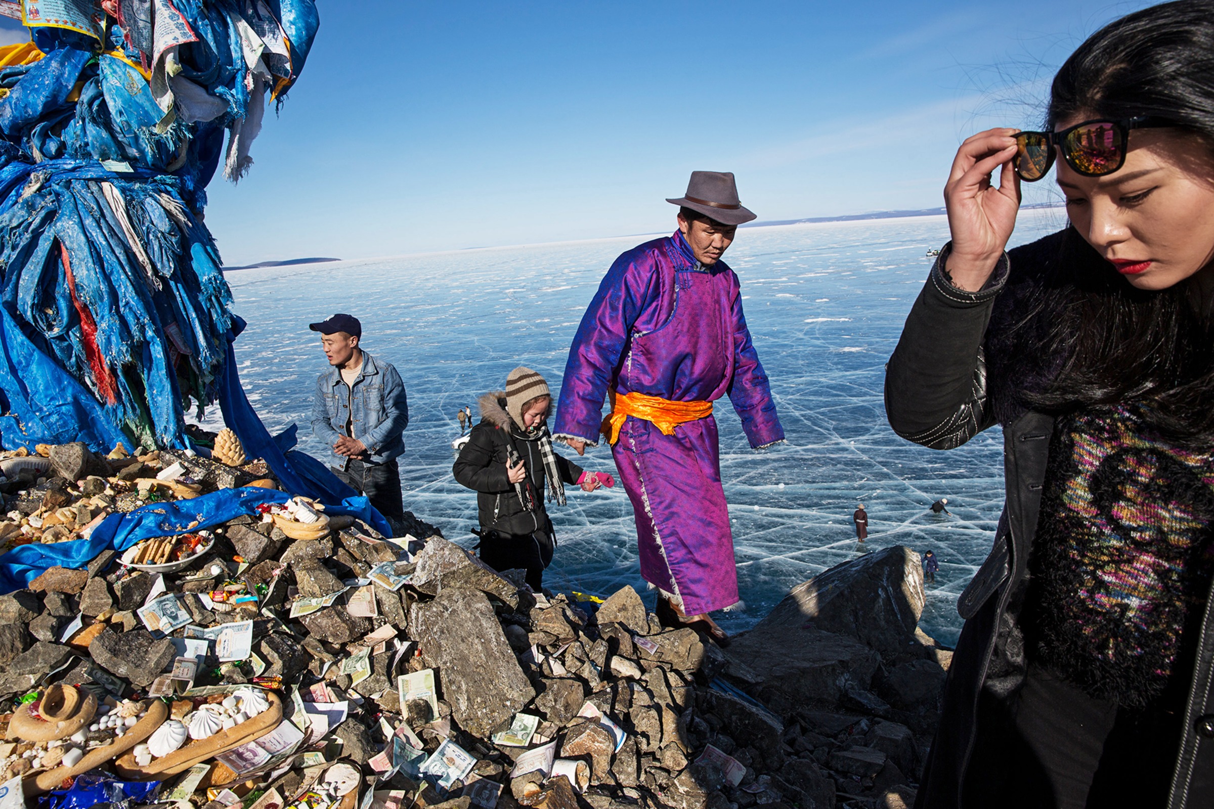 Mongolian men and women pray and make offerings at an Ovoo near the Lake Khovsgol Ice Festival in Khatgal, Mongolia. (Taylor Weidman—LightRocket/Getty Images)