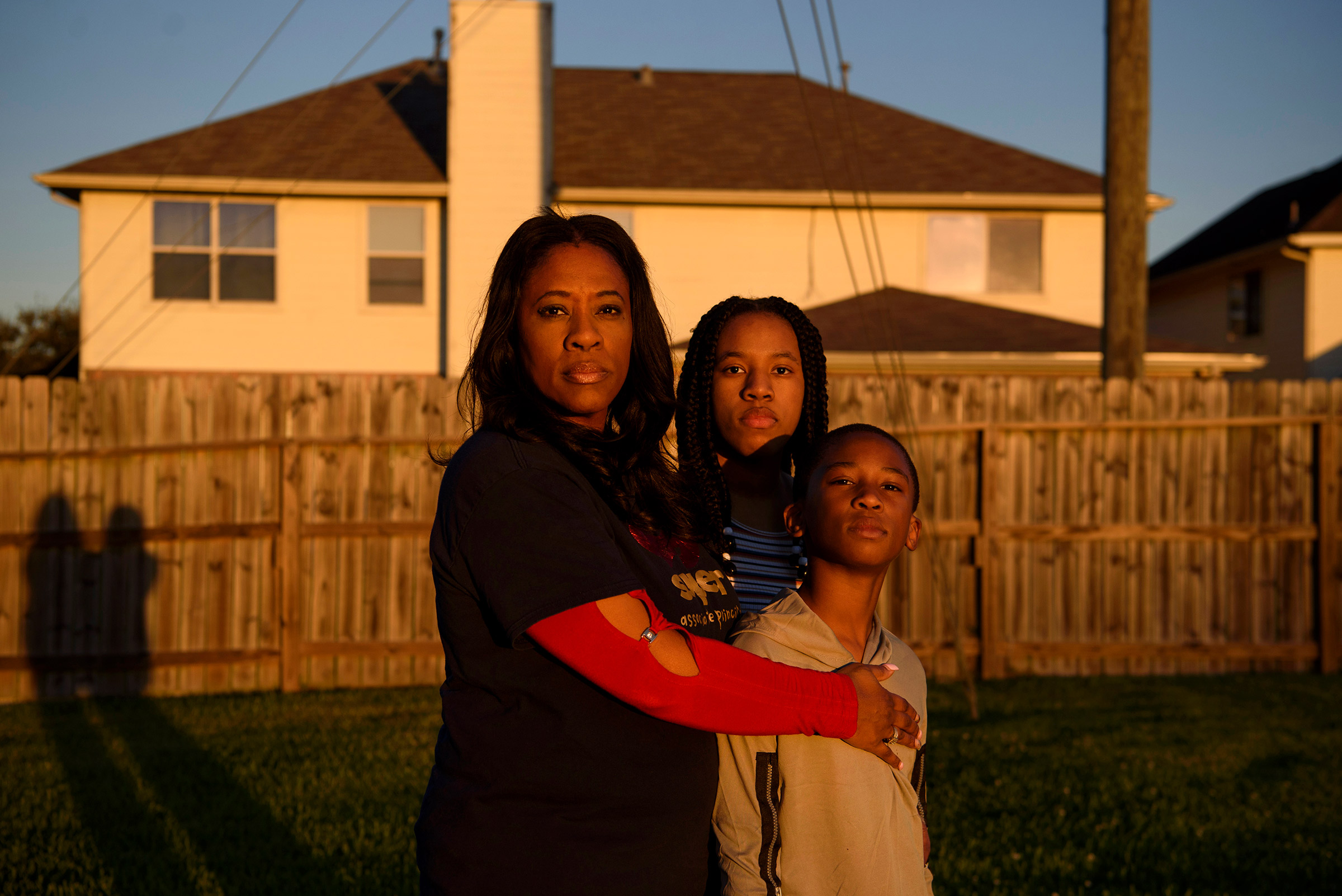 Ebony James, 50, poses with Adin, 8, and  Madison, 16, at home in Fresno, Texas. In February, her husband, Terrence James, died from COVID-19 related illness. (Callaghan O'Hare for TIME)