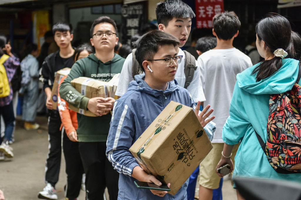 College students carrying packages at an online shopping pick up point in Haikou, China, on Singles' Day, Nov, 11, 2020 (Sheldon Cooper/SOPA Images/LightRocket via Getty Images)