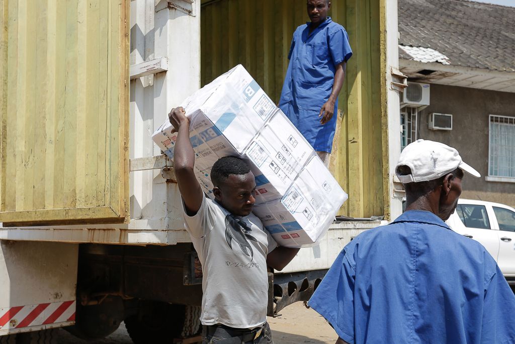 Workers unload boxes of about 500,000 donated doses of China's Sinopharm vaccine in Bujumbura, the economic capital of Burundi, on Oct.14, 2021. (TCHANDROU NITANGA/AFP via Getty Images)