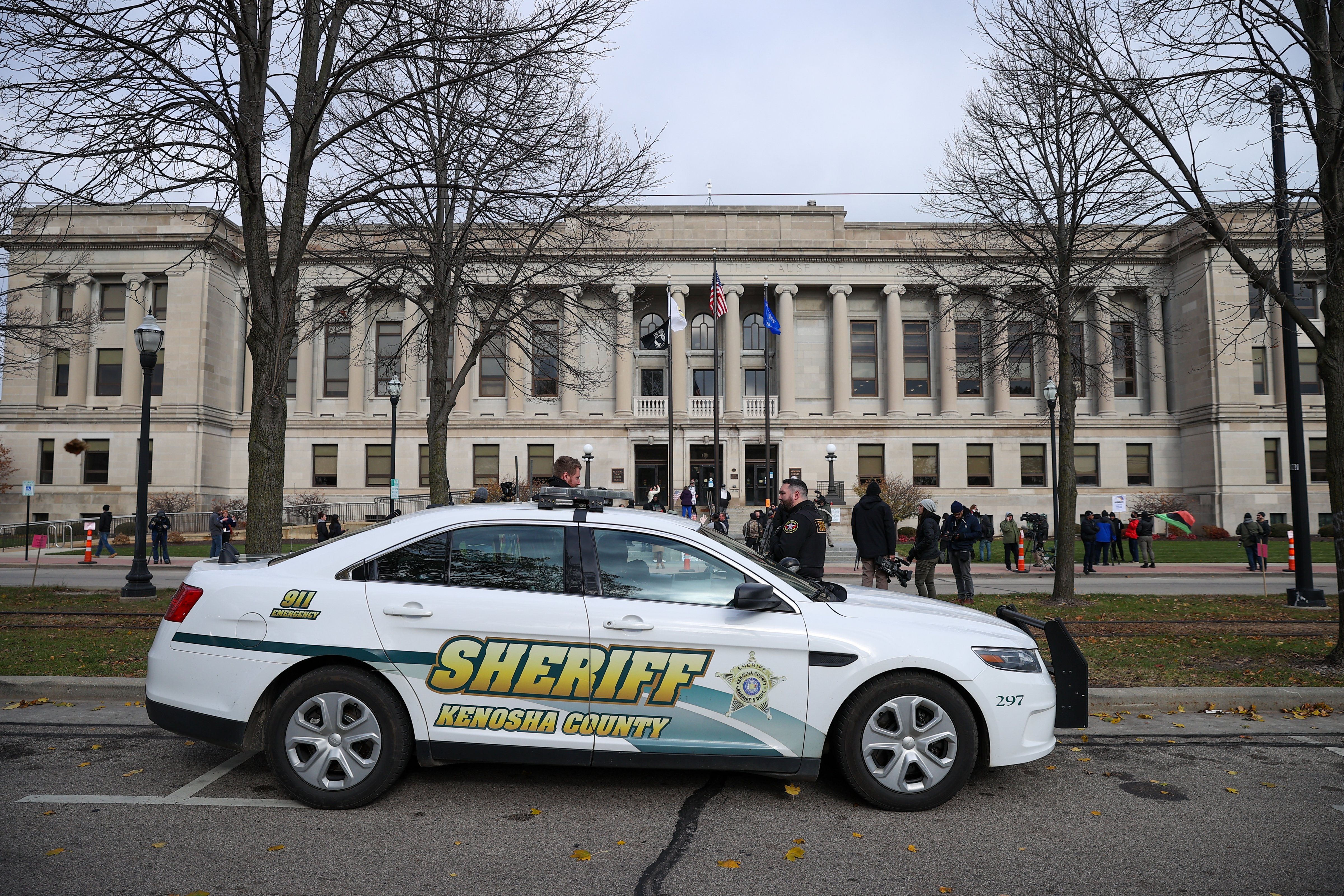 Law enforcement officers keep watch on a crowd outside the courthouse in Kenosha, Wisconsin, on Nov. 16, 2021 as jurors begin deliberations in the murder trial of Kyle Rittenhouse. (Tayfun Coskup—Anadolu Agency/ Getty Images)
