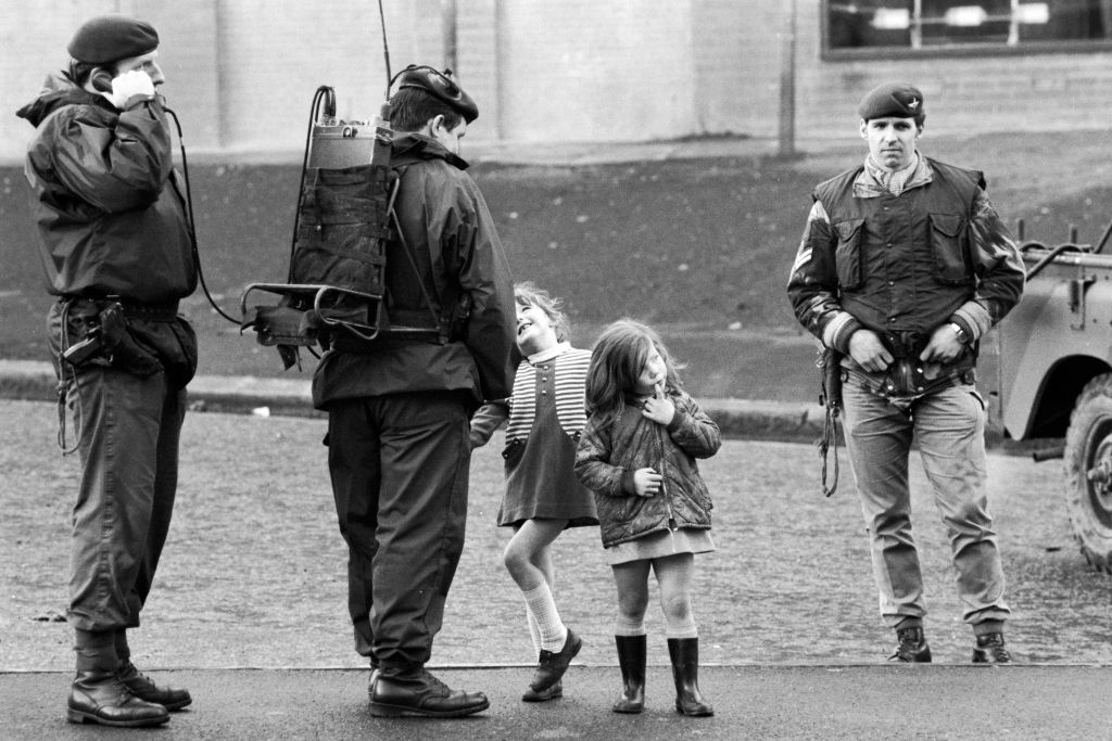 Two young girls stand with members of the British Army's Parachute Regiment in the primarily Catholic Divis Flats housing estate, Belfast, Northern, Ireland, August 10, 1969 (Leif Skoogfors/Corbis via Getty Images)
