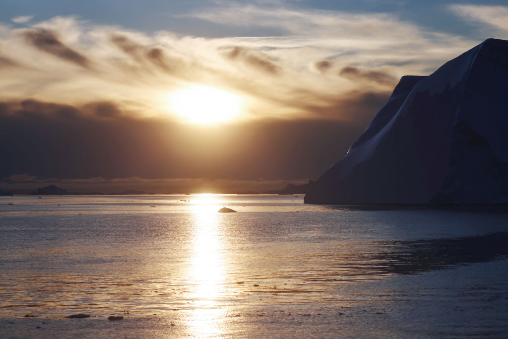 The sun sets beyond Icebergs which calved from the Sermeq Kujalleq glacier float in the Ilulissat Icefjord on September 05, 2021 in Ilulissat, Greenland. 2021 will mark one of the biggest ice melt years for Greenland in recorded history. Researchers from Denmark estimated that in July of this year enough ice melted on the Greenland Ice Sheet to cover the entire state of Florida with two inches of water. According to NASA, Greenland has melted 5 trillion tons of ice over approximately the past 15 years, enough to increase global sea level by nearly an inch. (Mario Tama-Getty Images)