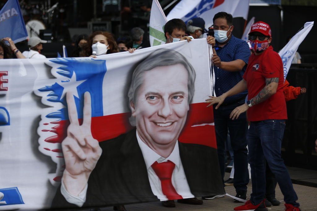 Supporters of Chilean presidential candidate Jose Antonio Kast of the Republican Party hold a flag during the presidential campaign closing rally on November 18, 2021 in Santiago, Chile. Chileans will go to the polls on November 21. (Marcelo Hernandez—Getty Images)