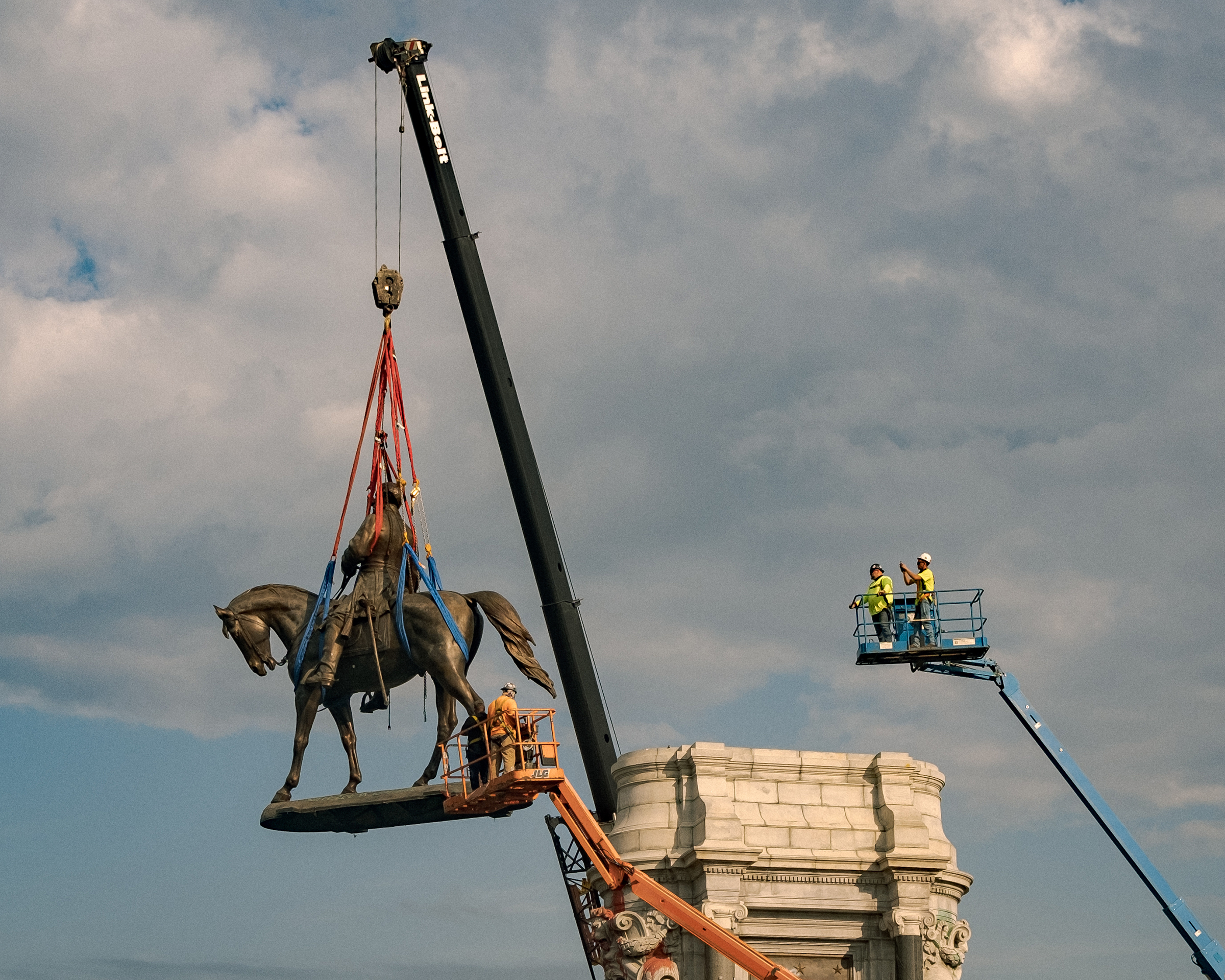 The statue of Robert E. Lee, the Confederate general and icon of a <a href="https://time.com/6096224/richmond-robert-e-lee-statue/">much mythologized chapter of American history</a>, is lowered from its plinth during its removal after 131 years in Richmond, Va., on Sept. 8. (Amr Alfiky—National Geographic/Pool/Getty Images)