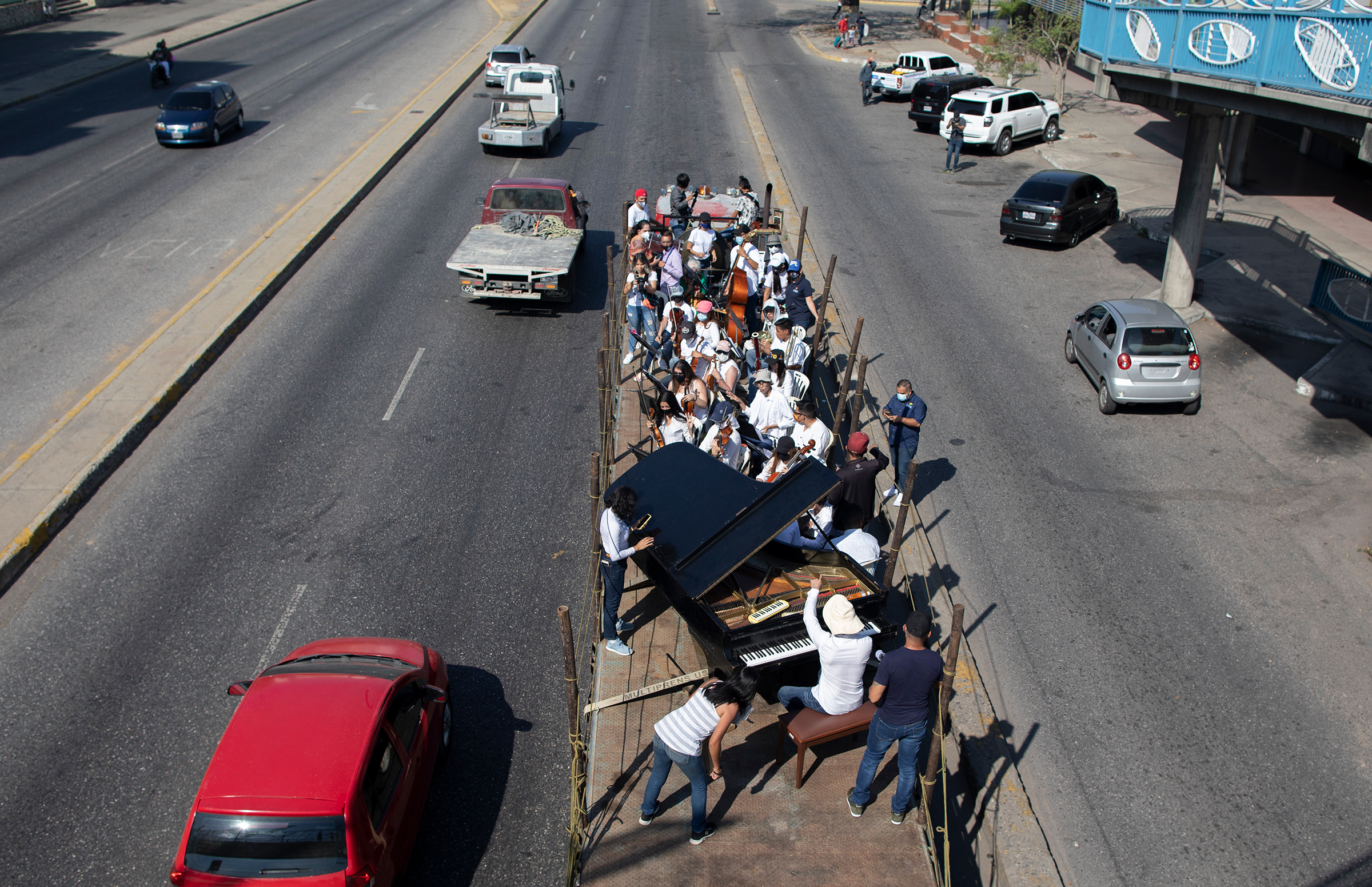 Musicians join pianist, composer and conductor José Agustín Sánchez on a truck bed for a "musical disinfection" in Barquisimeto, northwestern Venezuela, on March 4, 2021. Sanchez, who last year started playing what he calls his "Musical Vaccine" for COVID-19 patients, is now joined by other musicians as they ride through the city playing his original compositions for anybody who wants to listen.