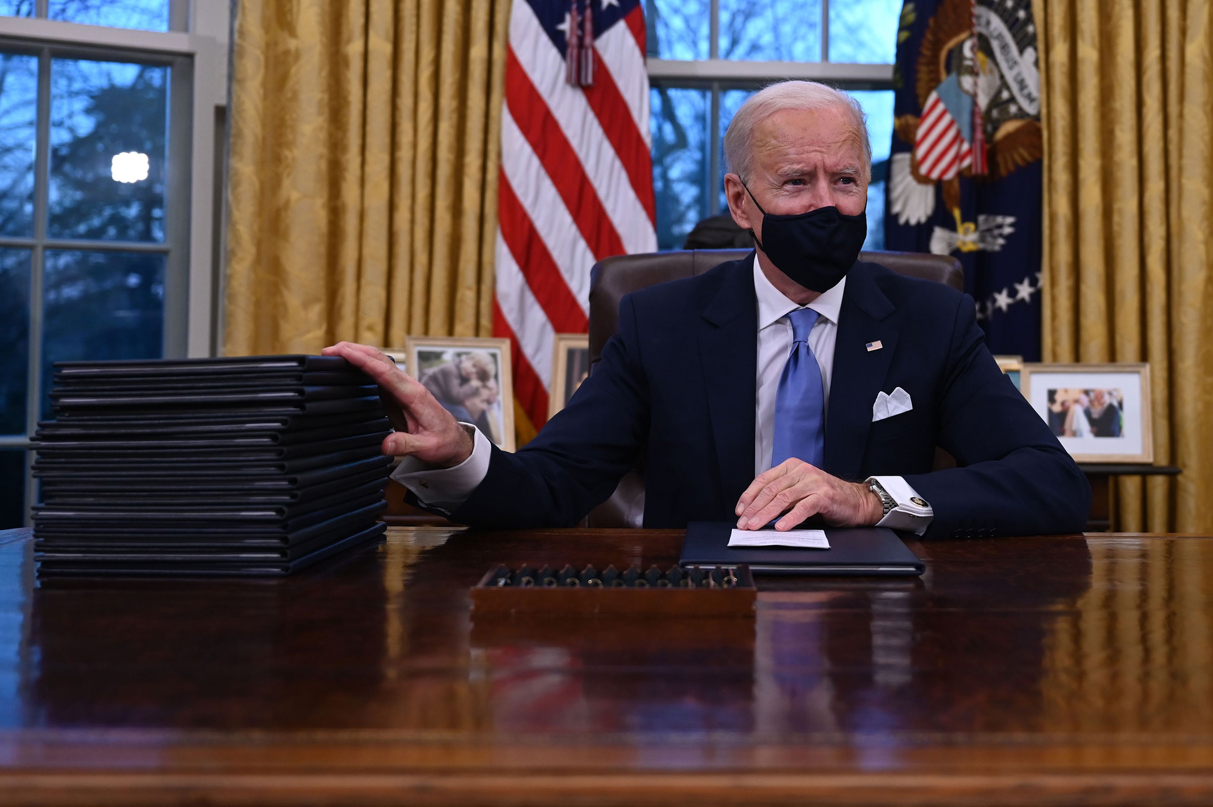 US President Joe Biden prepares to sign a series of orders, including an order to strengthen the fight against Covid-19, in the Oval Office of the White House in Washington, DC, on January 20, 2021. (Jim Watson—AFP/Getty Images)