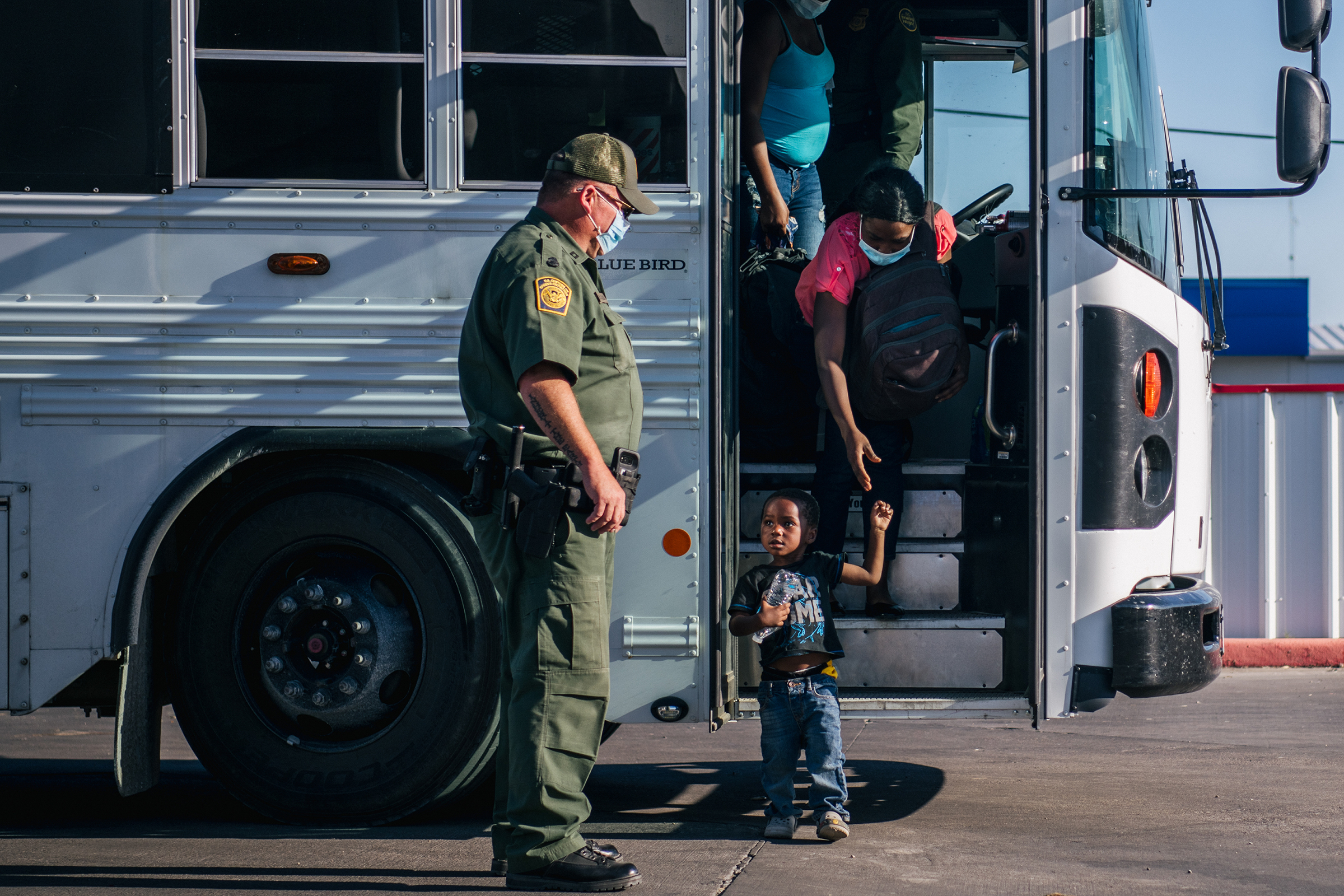 A young boy exits a U.S. Border Patrol bus with migrants preparing to be received by the Val Verde Humanitarian Coalition after crossing the Rio Grande in Del Rio, Texas, on Sept. 22, 2021.