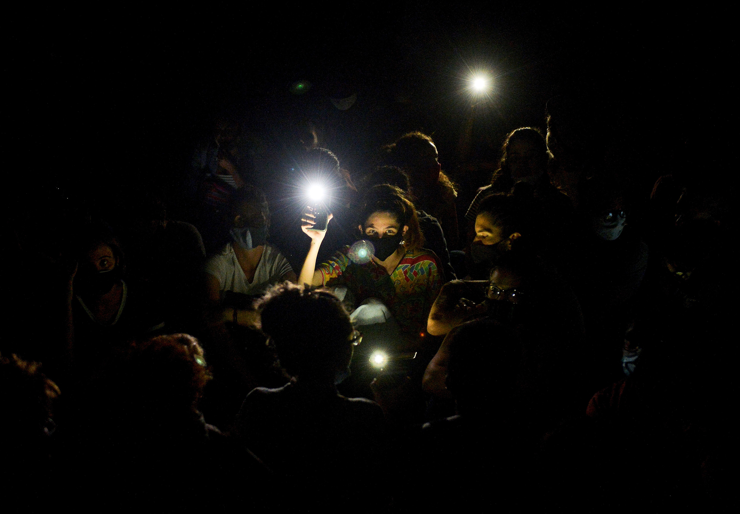 A group of young activists and artists hold up lights on their mobile phones as they demonstrate at the doors of the Ministry of Culture in Havana in November 2020 (Yamil Lage—AFP/Getty Images)