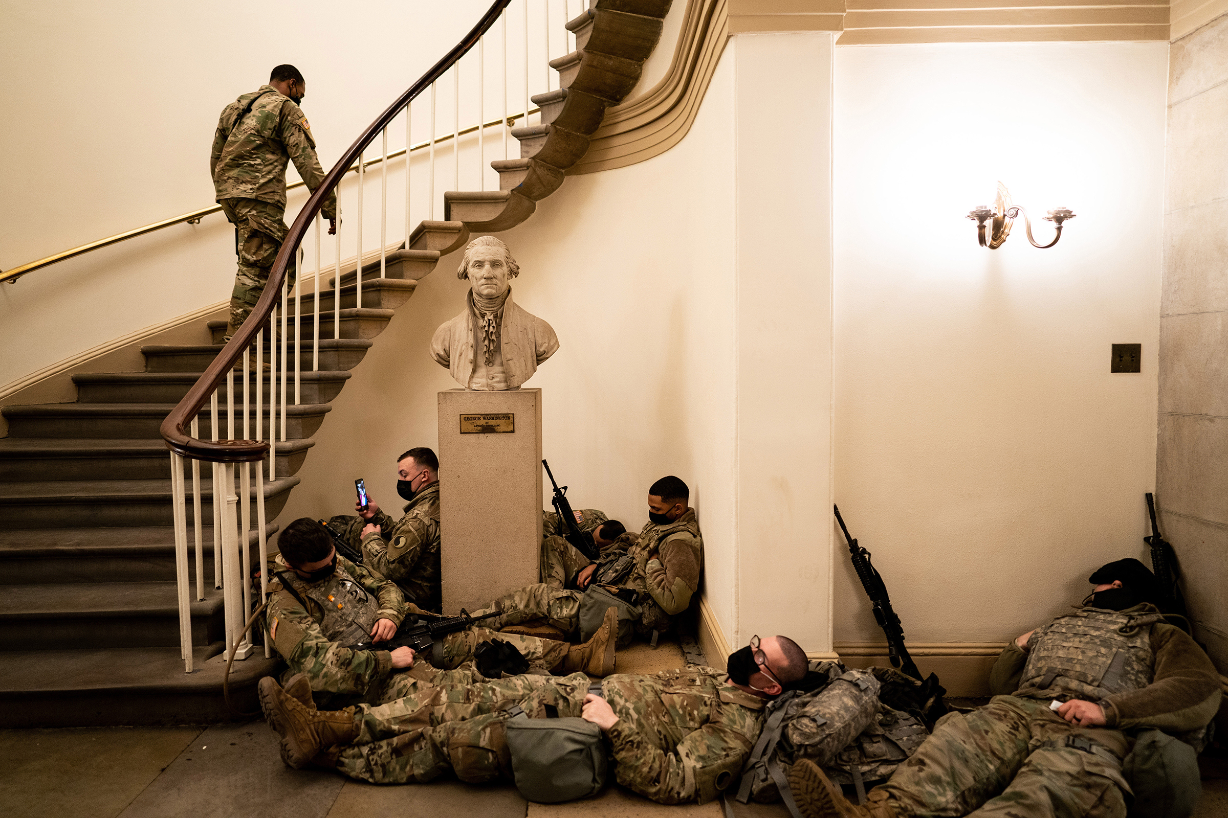 Members of the National Guard rest in the Capitol during a break in shifts as the House of Representatives prepares to vote on impeaching President Donald Trump in Washington, D.C., on Jan. 13. Trump was impeached a historic second time, one week before the end of his presidency. (Erin Schaff—The New York Times/Redux)