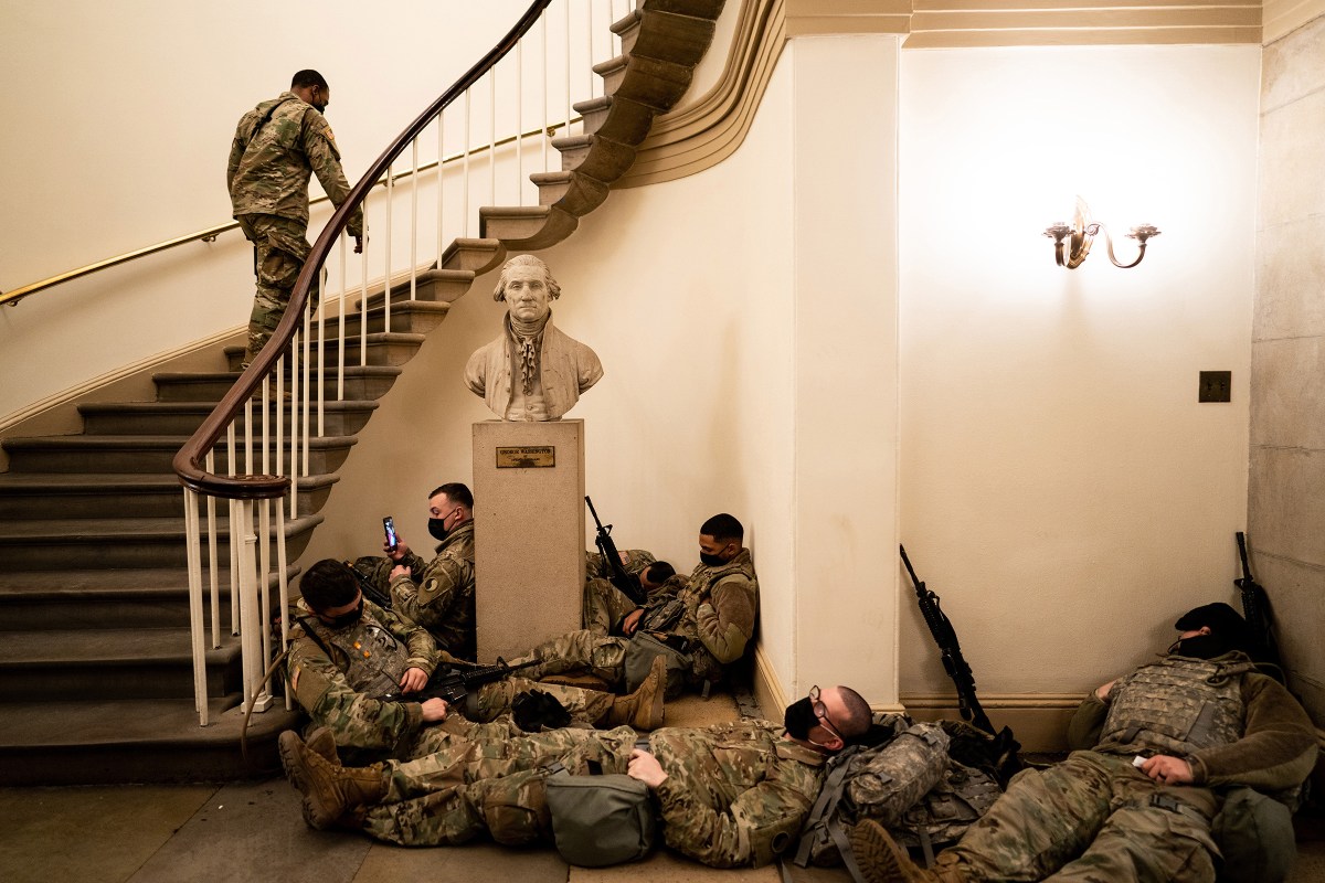 Members of the National Guard rest in the Capitol during a break in shifts as the House of Representatives prepares to vote on impeaching President Donald Trump in Washington, D.C., on Jan. 13. Trump was impeached a historic second time, one week before the end of his presidency, for "incitement of insurrection."