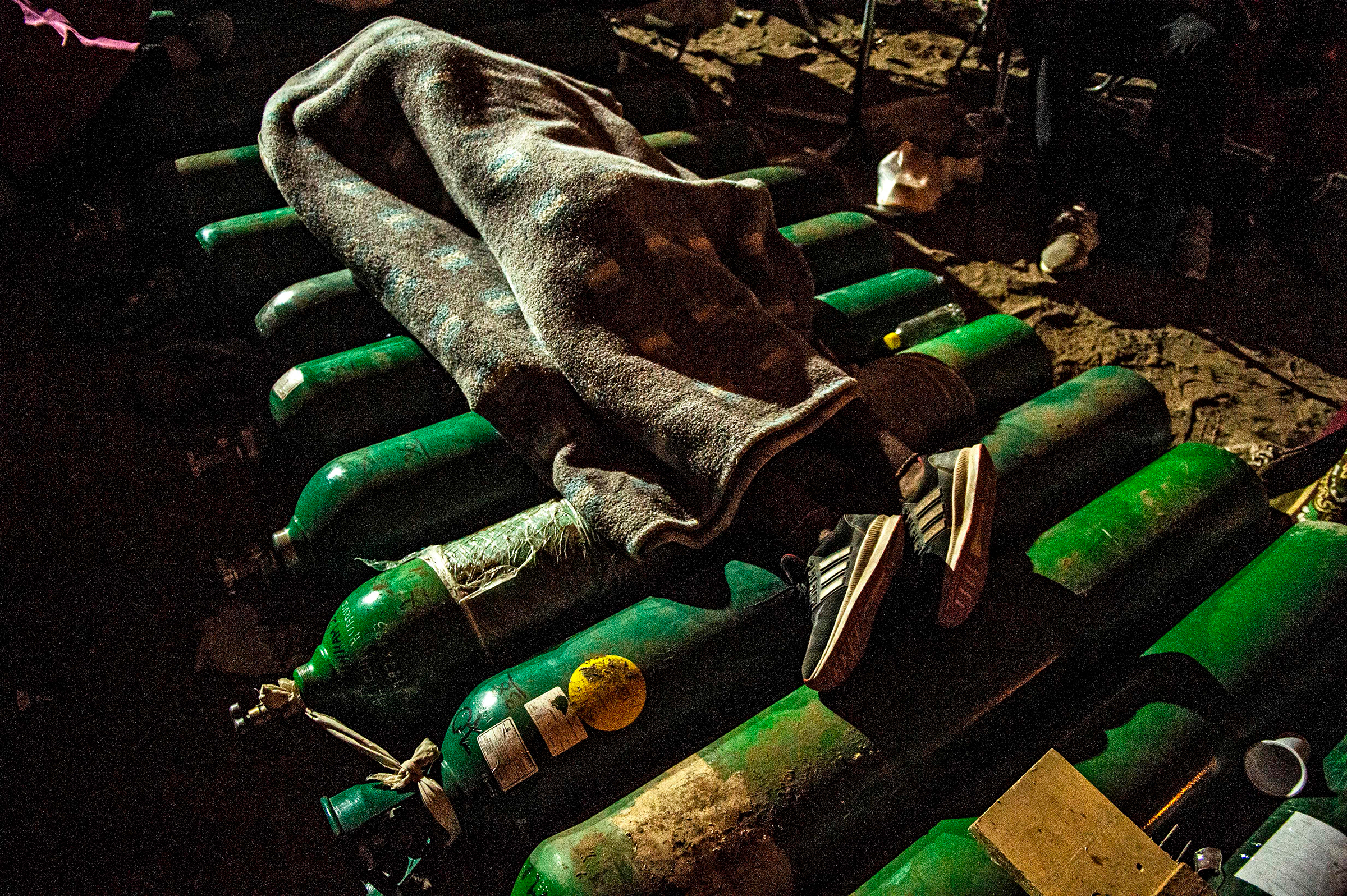 A person sleeps on empty oxygen cylinders while waiting to refill them in Villa El Salvador, on the southern outskirts of Lima, on Feb. 25, 2021. Relatives of COVID-19 patients were desperate for oxygen to keep their loved ones alive during a fierce second wave of the pandemic in Peru.