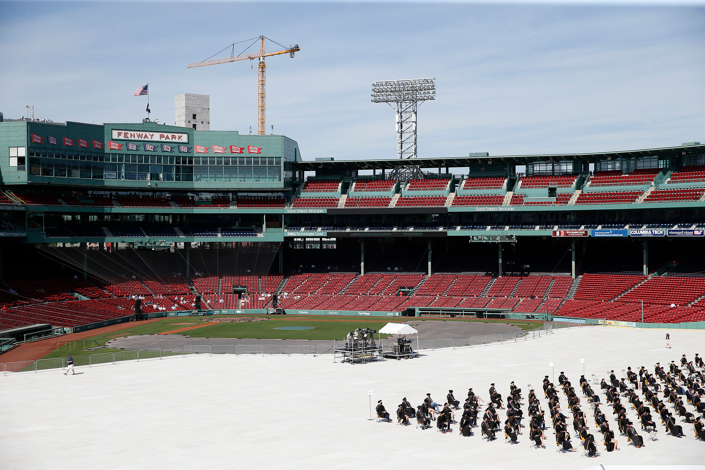 Law school graduates of Suffolk University are seated on socially distanced folding chairs as members of the class of 2020 celebrate their long-awaited graduation at Fenway Park in Boston on May 23. (Jessica Rinaldi—The Boston Globe/Getty Images)