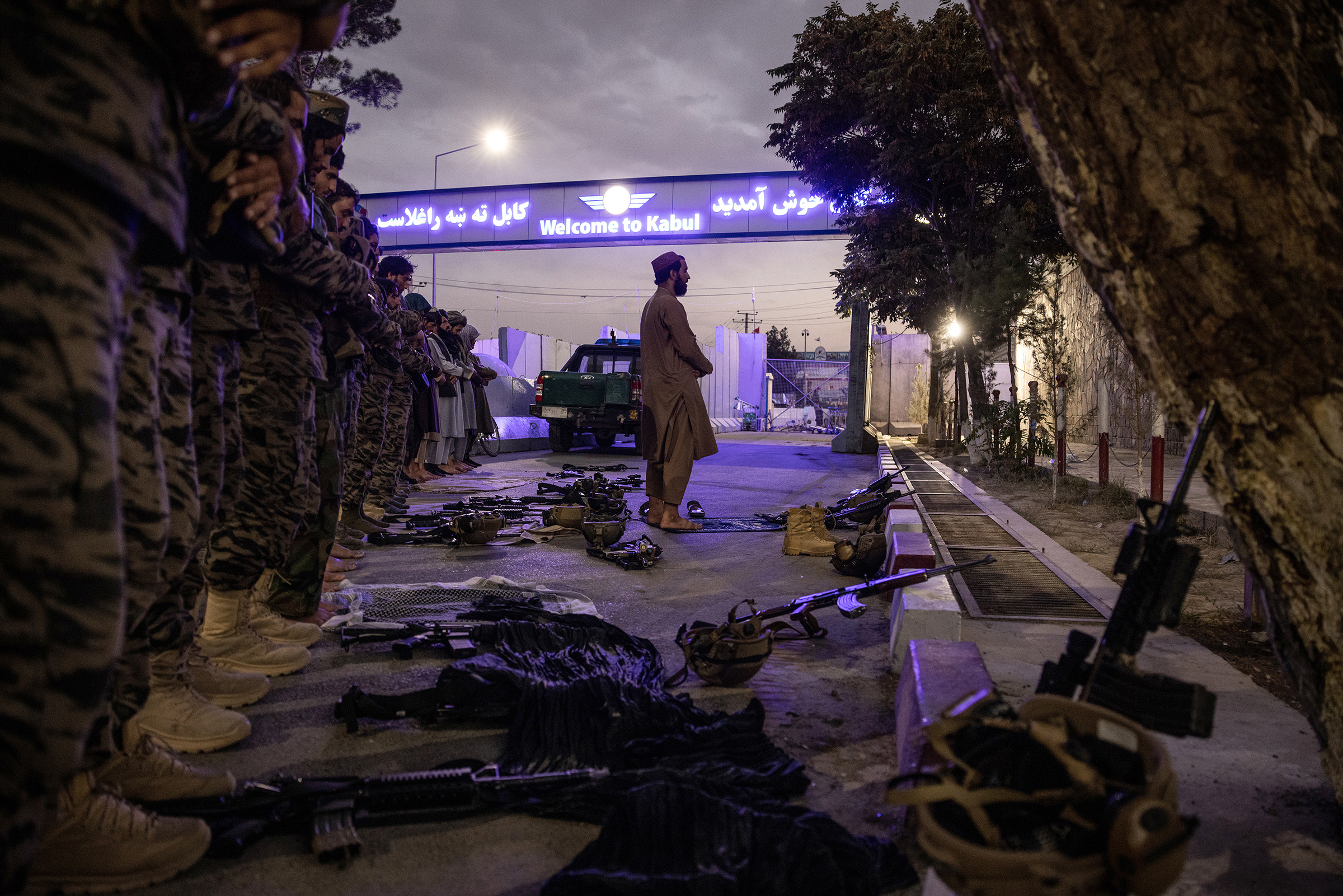 Members of the Badri 313 Battalion, a group of Taliban fighters, stand during evening prayers near Hamid Karzai International Airport in Kabul on Aug. 28. (Jim Huylebroek—The New York Times/Redux)
