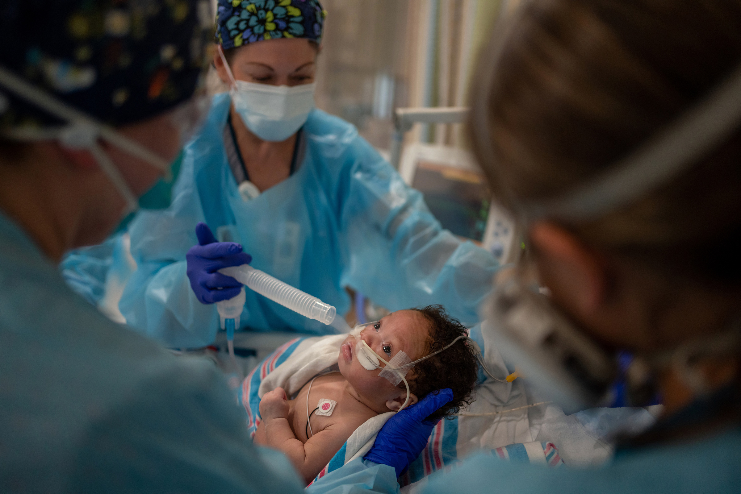 Respiratory therapist Diane Gelpi administers oxygen to Carvase Perrilloux after he was <a href="https://time.com/6092446/pediatric-covid-19-surge/">taken off a ventilator</a> at Children’s Hospital New Orleans on Aug. 20. The two-month-old, who arrived about a week earlier with respiratory syncytial virus and COVID-19, was finally ready to breathe without the ventilator keeping his tiny body alive. "You did it!" nurses in PPE cooed as they removed the tube from his airway and he took his first solo gasp, bare toes kicking. (Kathleen Flynn for TIME)