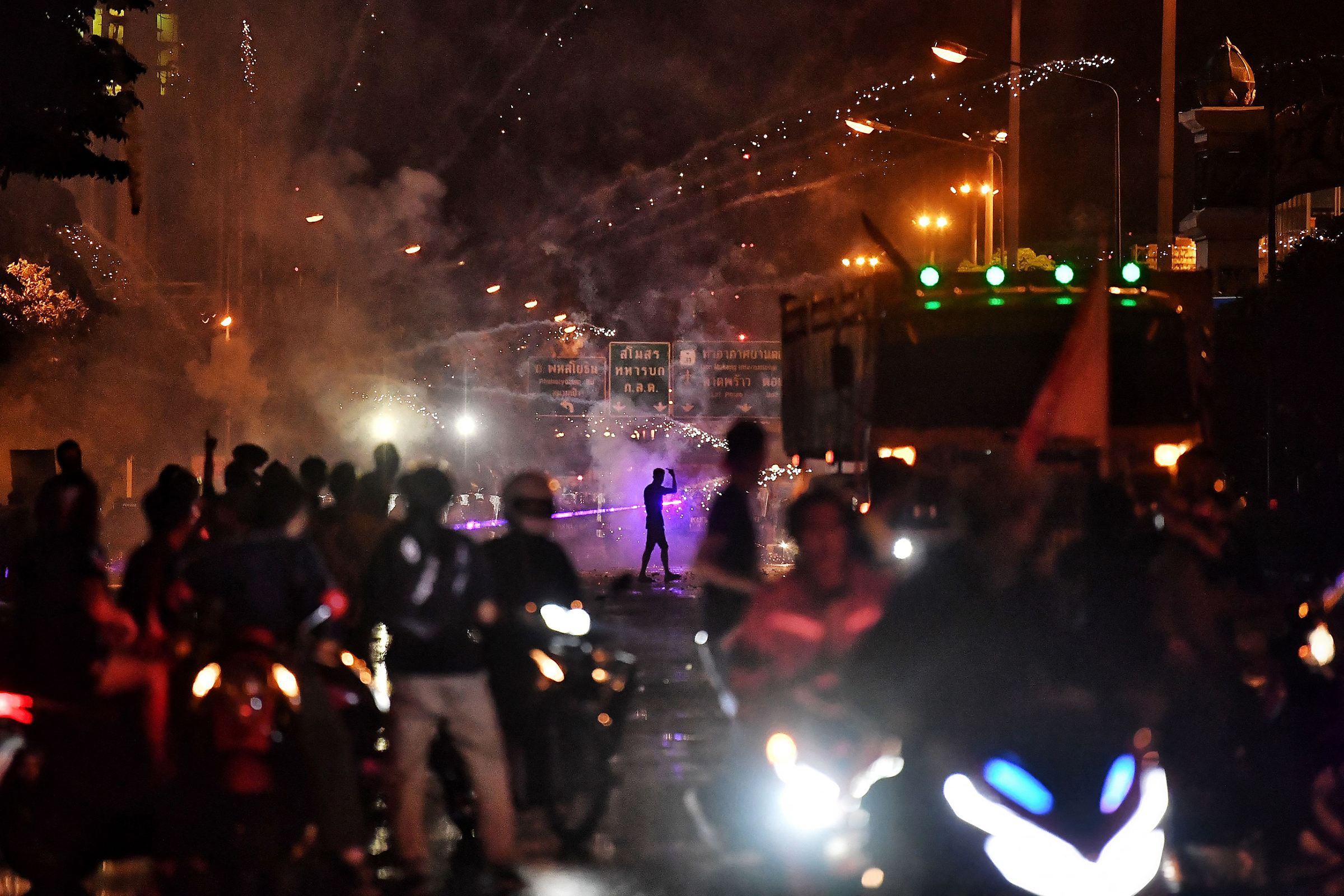 Anti-government protesters set off firecrackers near riot police during a Sept. 5 demonstration in Bangkok calling for the resignation of Thailand's prime minister over the government's coronavirus response. (Lillian Suwanrumpha—AFP/Getty Images)