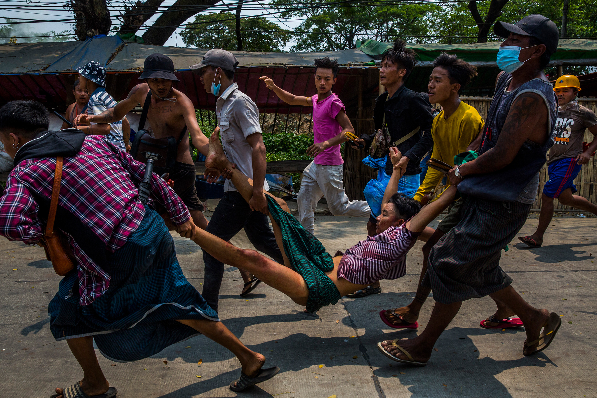 People carry a man who was shot during a crackdown on anti-coup protesters on the outskirts of Yangon, Myanmar on March 14. (Panos Pictures/Redux)